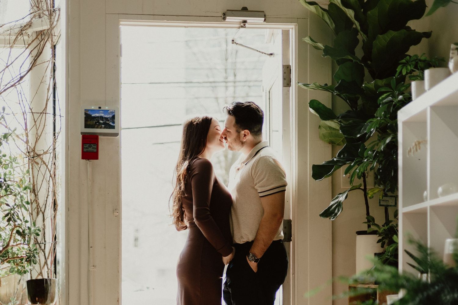 Romantic indoor scene with soft natural light streaming through doorway and plants.