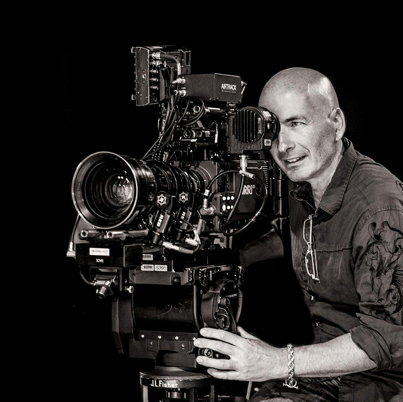 Black and white portrait of Alec Watson operating an Arri film camera, photographer Vanessa Parise