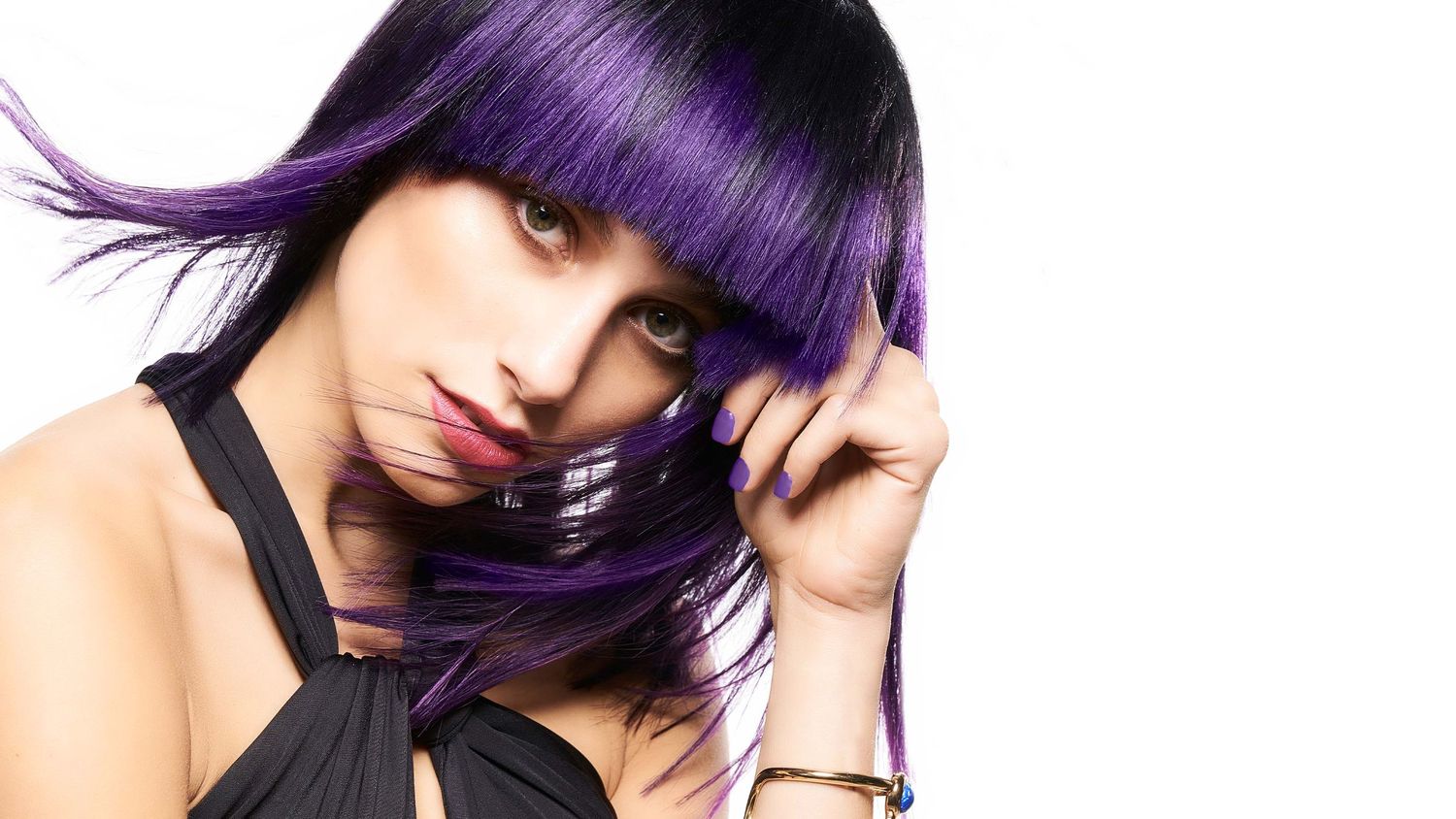 Woman with vibrant purple hair covering her face, wearing a black top, photographer Alec Watson