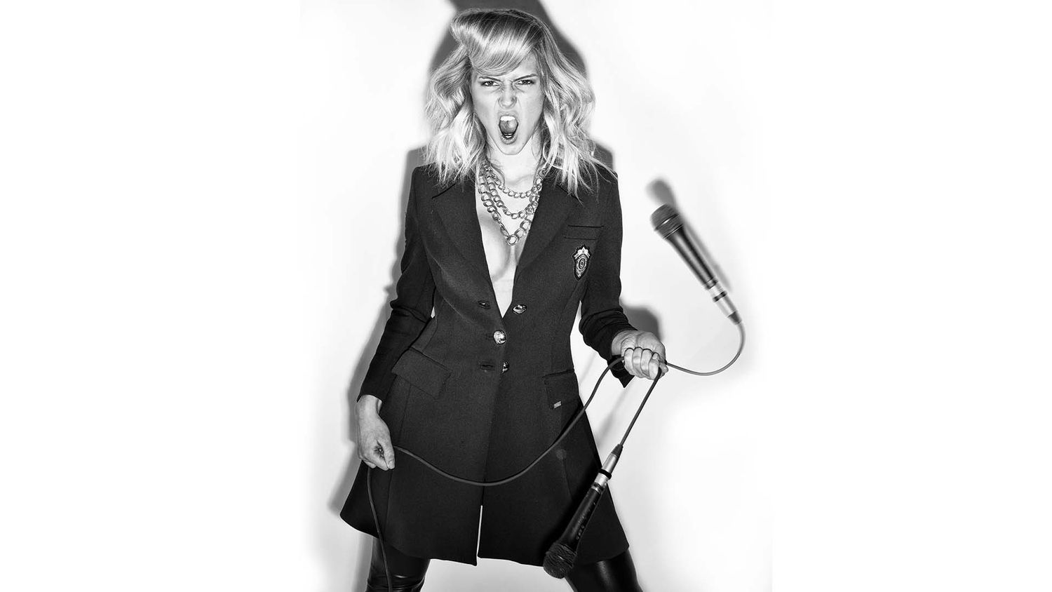 Black and white photo of a woman wearing a white jacket and dark pants, photographer Alec Watson
