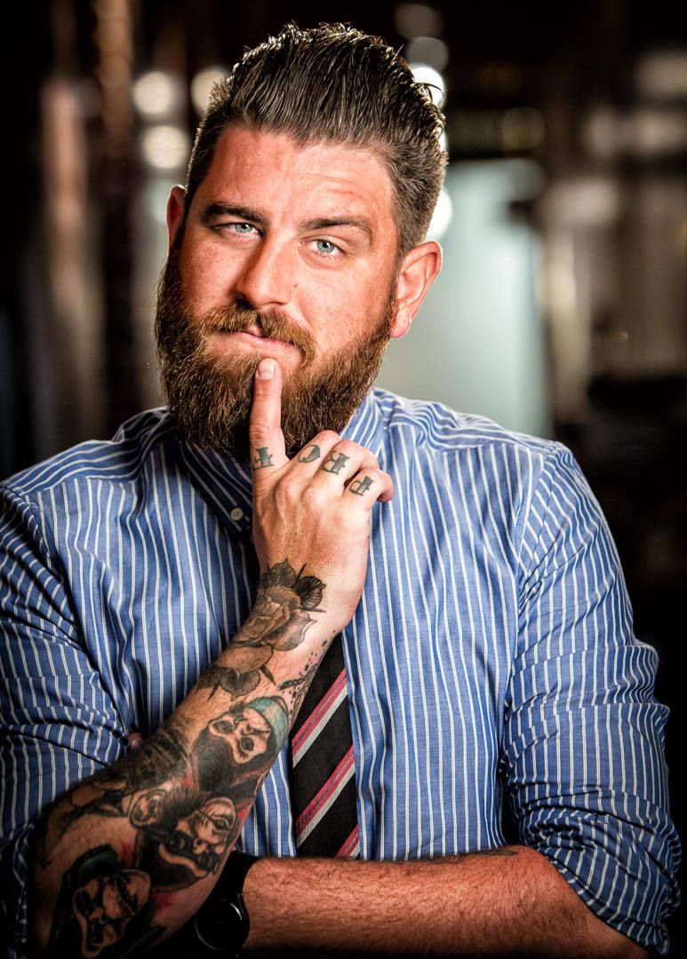 Portrait of a man with a moustache and beard wearing a blue plaid shirt, photographer Alec Watson