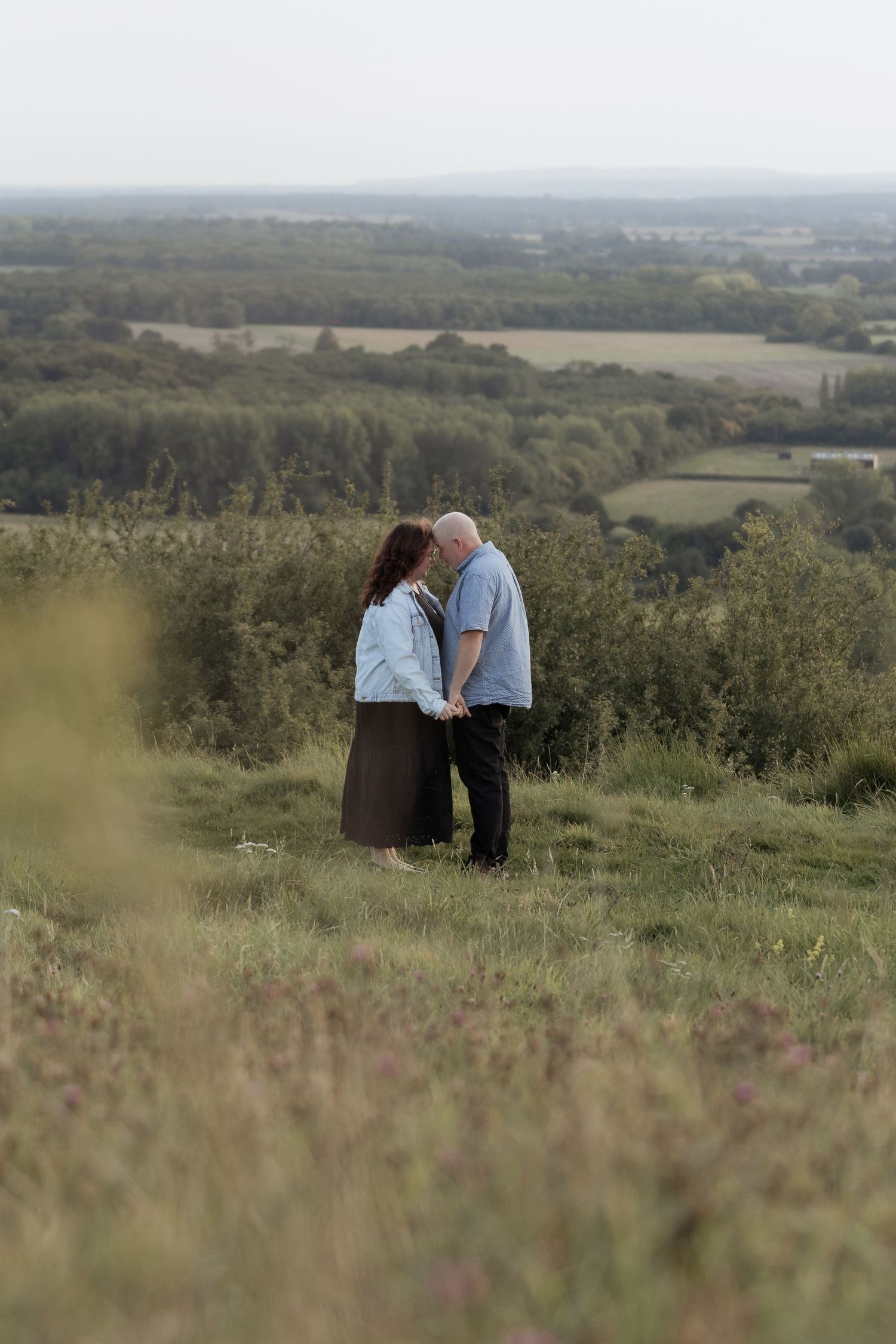 Scenic hilltop moment overlooking a vast landscape of rolling hills and forests.