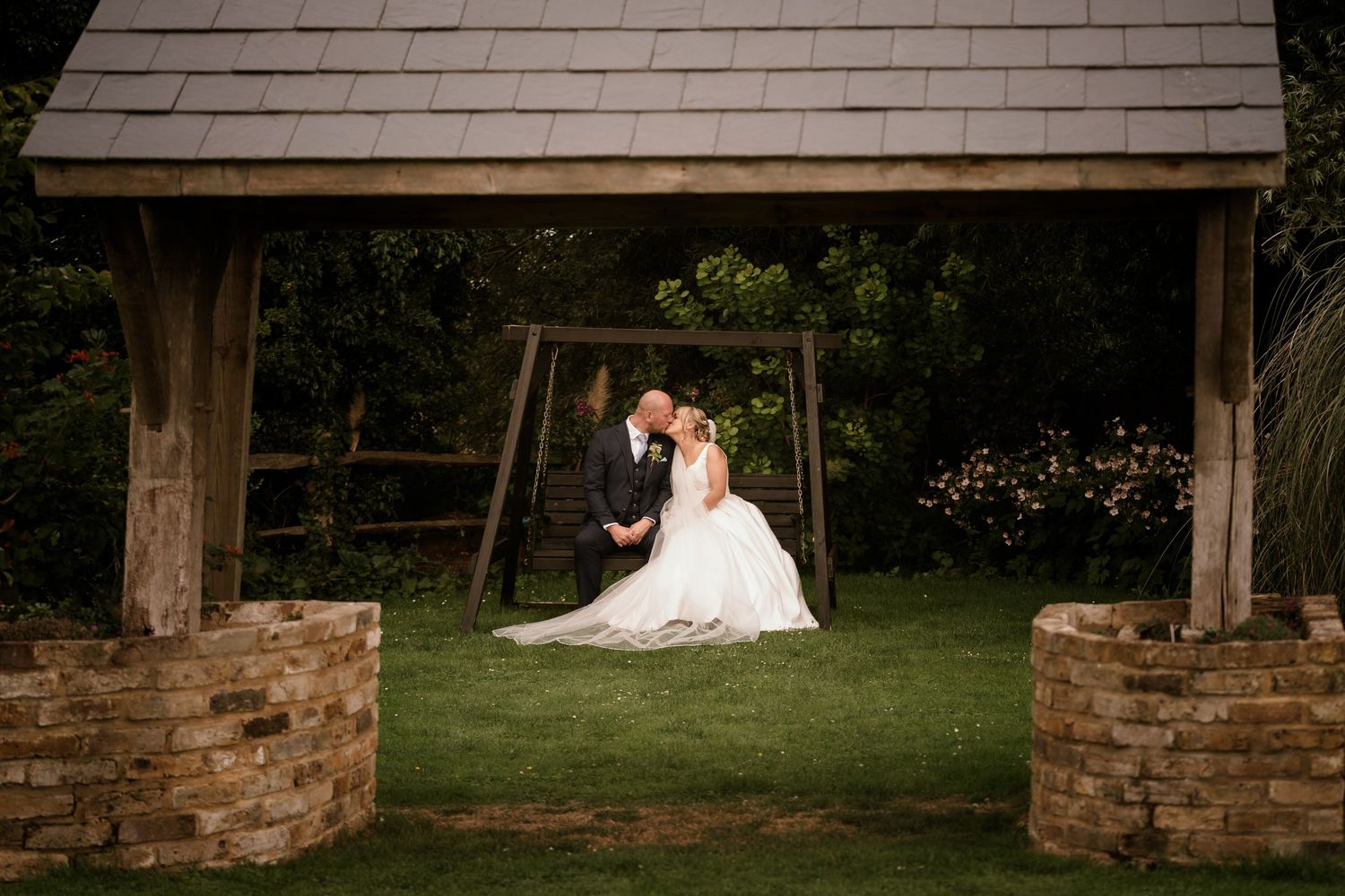 A rustic stone pavilion serves as a backdrop for wedding photography.