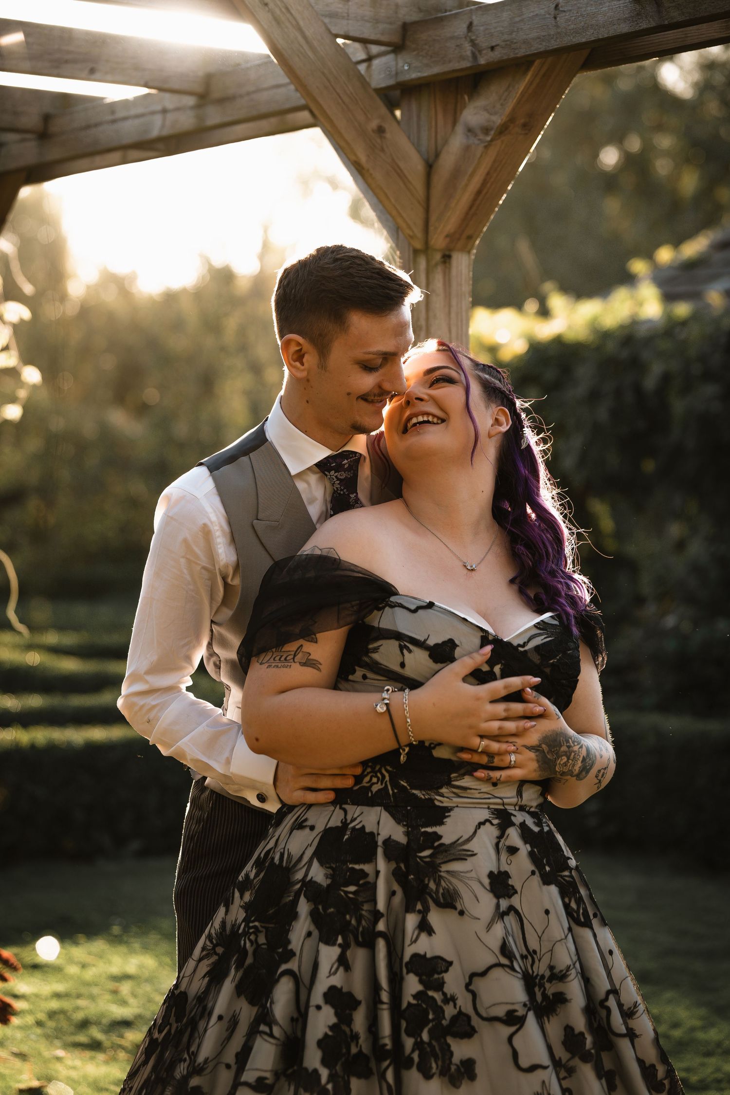 Intimate couple portrait session during golden hour under a wooden pergola.