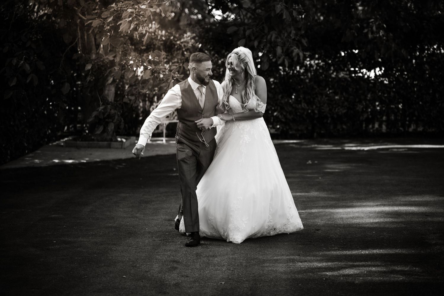 Dramatic black and white wedding portrait in garden setting.