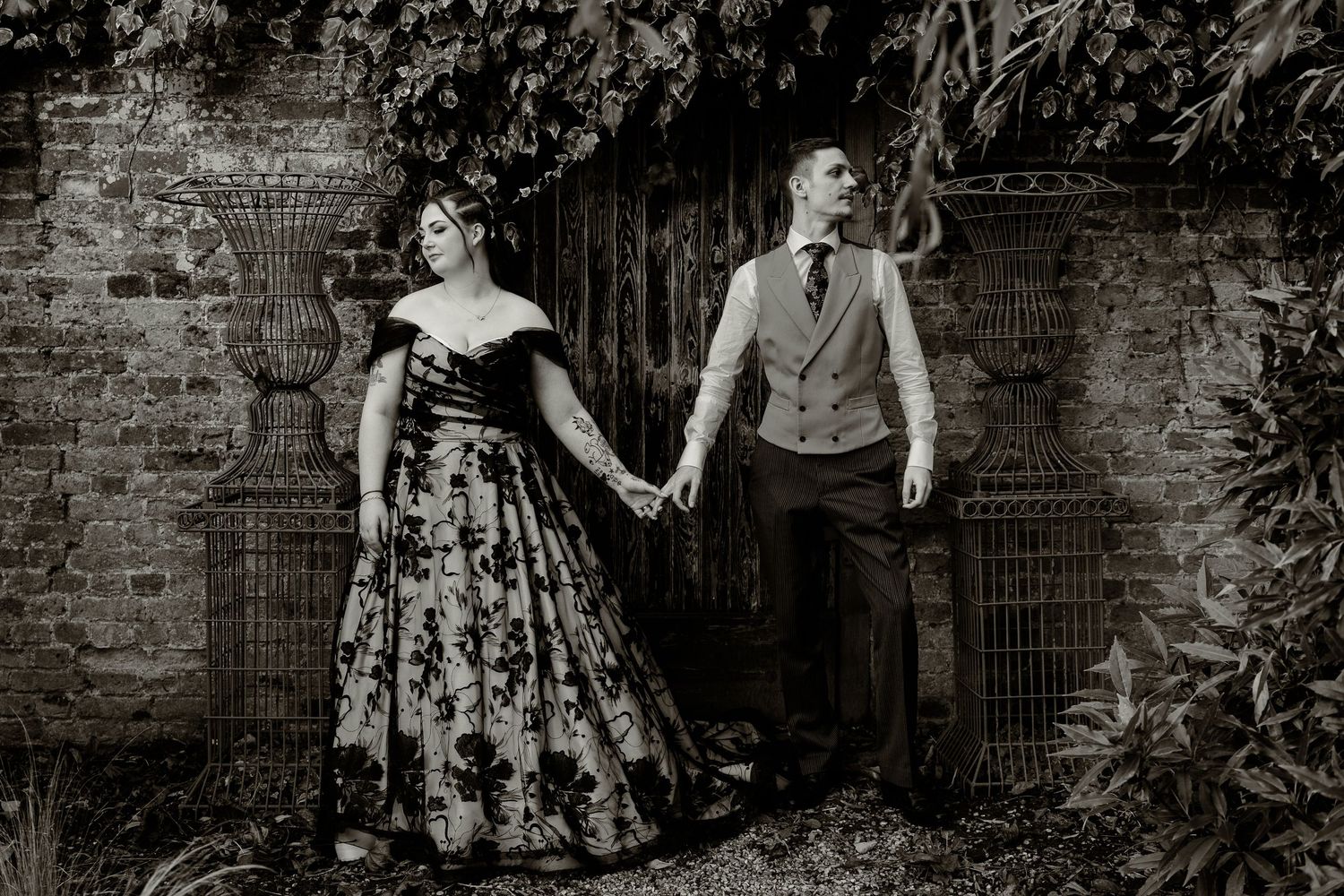Artistic black and white portraits against rustic brick wall backdrop.