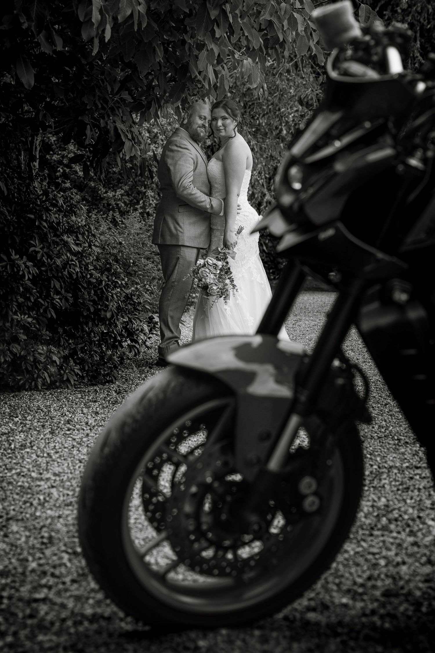 Artistic black and white wedding photos with a motorcycle silhouette in the foreground.