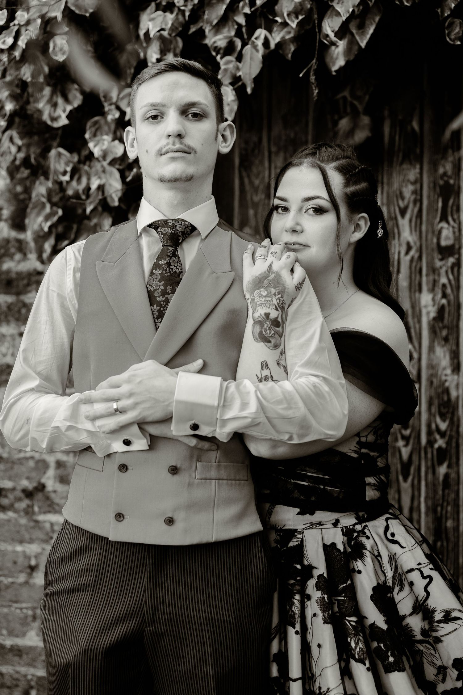 Vintage-styled portrait session featuring formal attire against a textured backdrop.