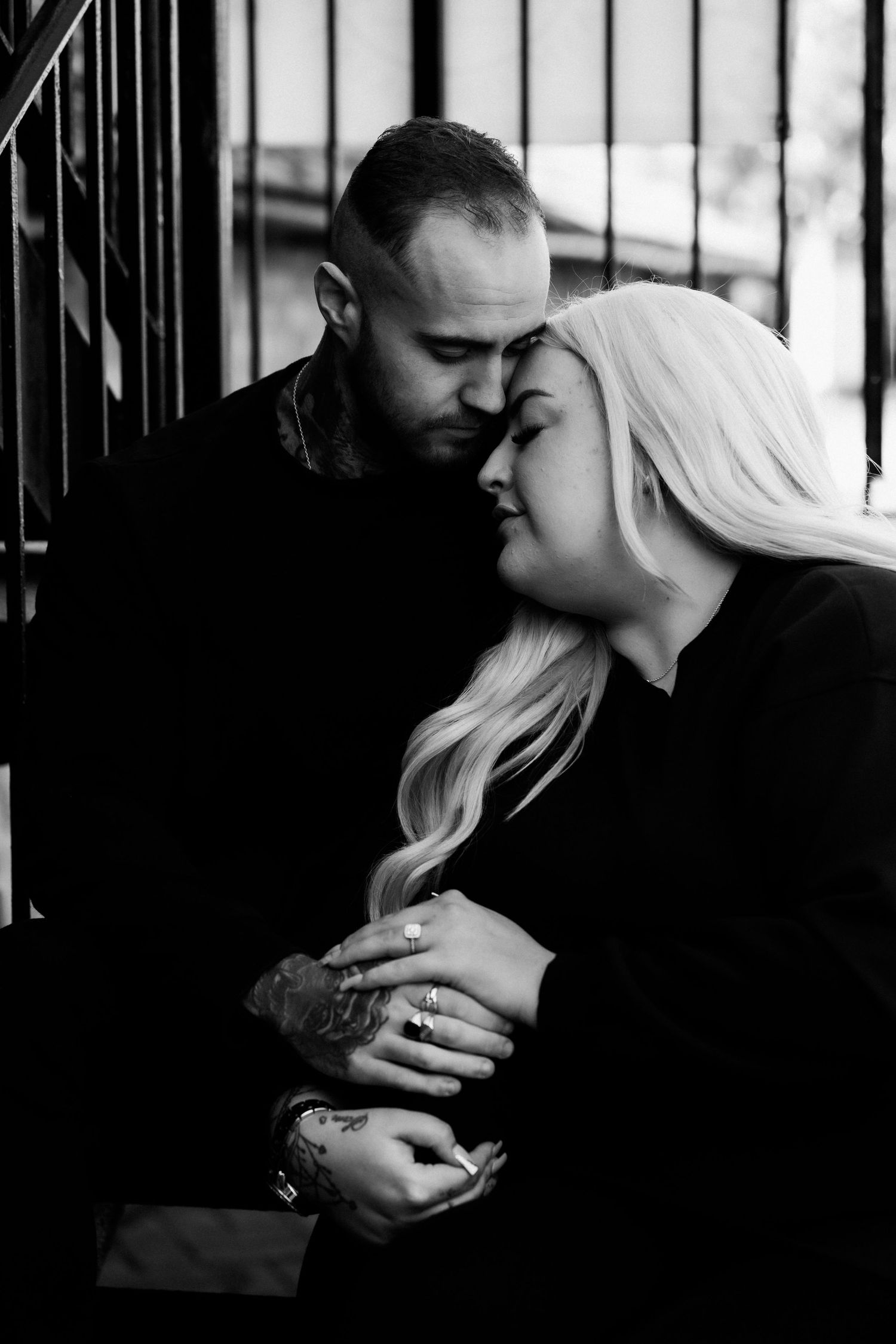 Intimate black and white portraits against iron railings.