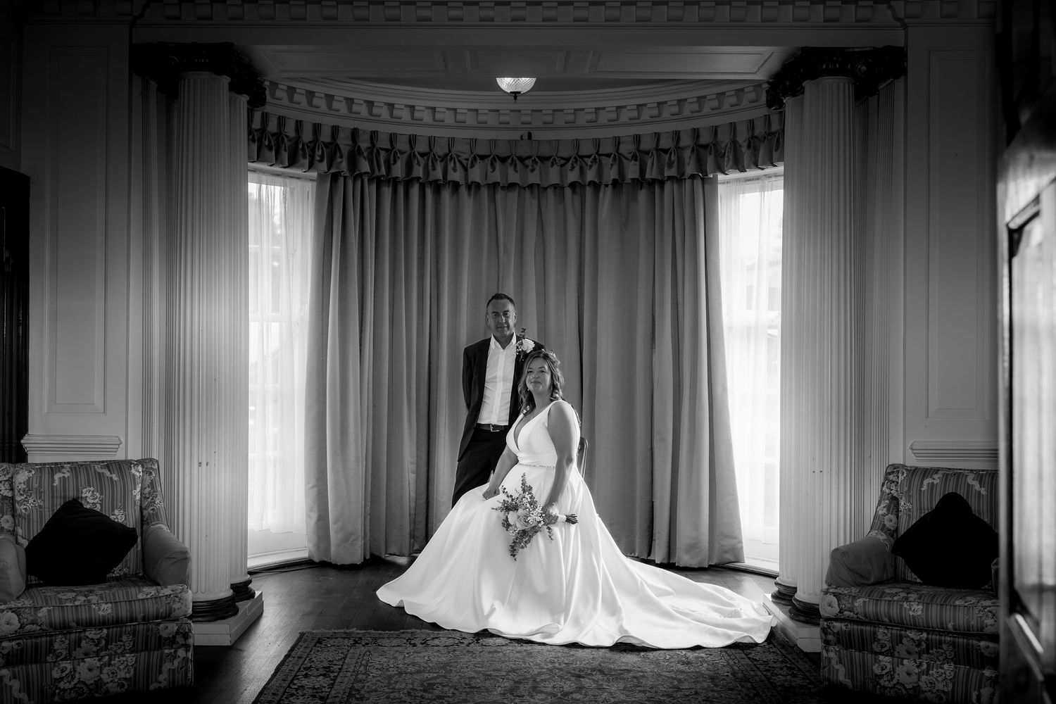 Black and white wedding photos showing a bride in an elegant dress against window light.