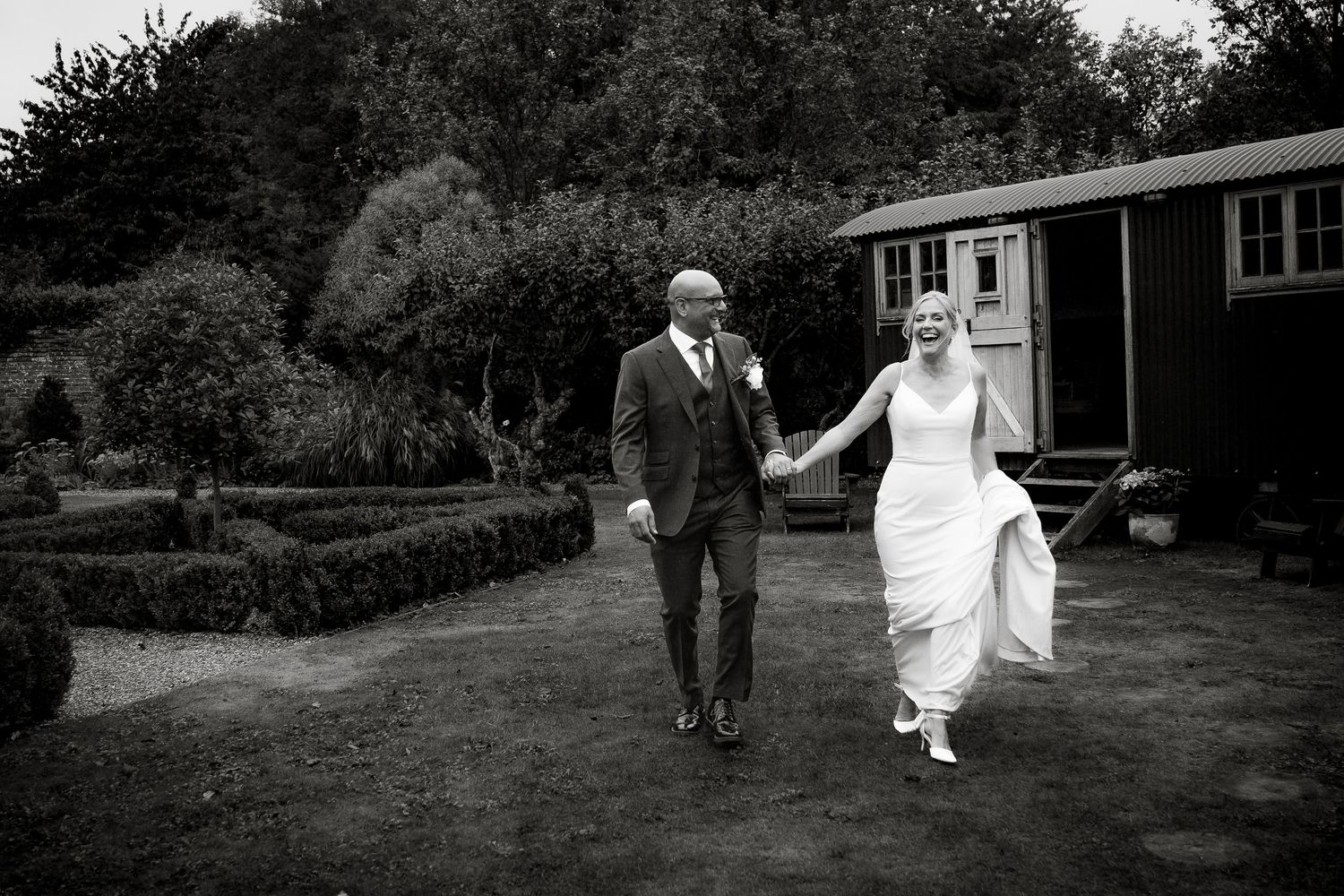 Black and white wedding portraits captured in garden setting.