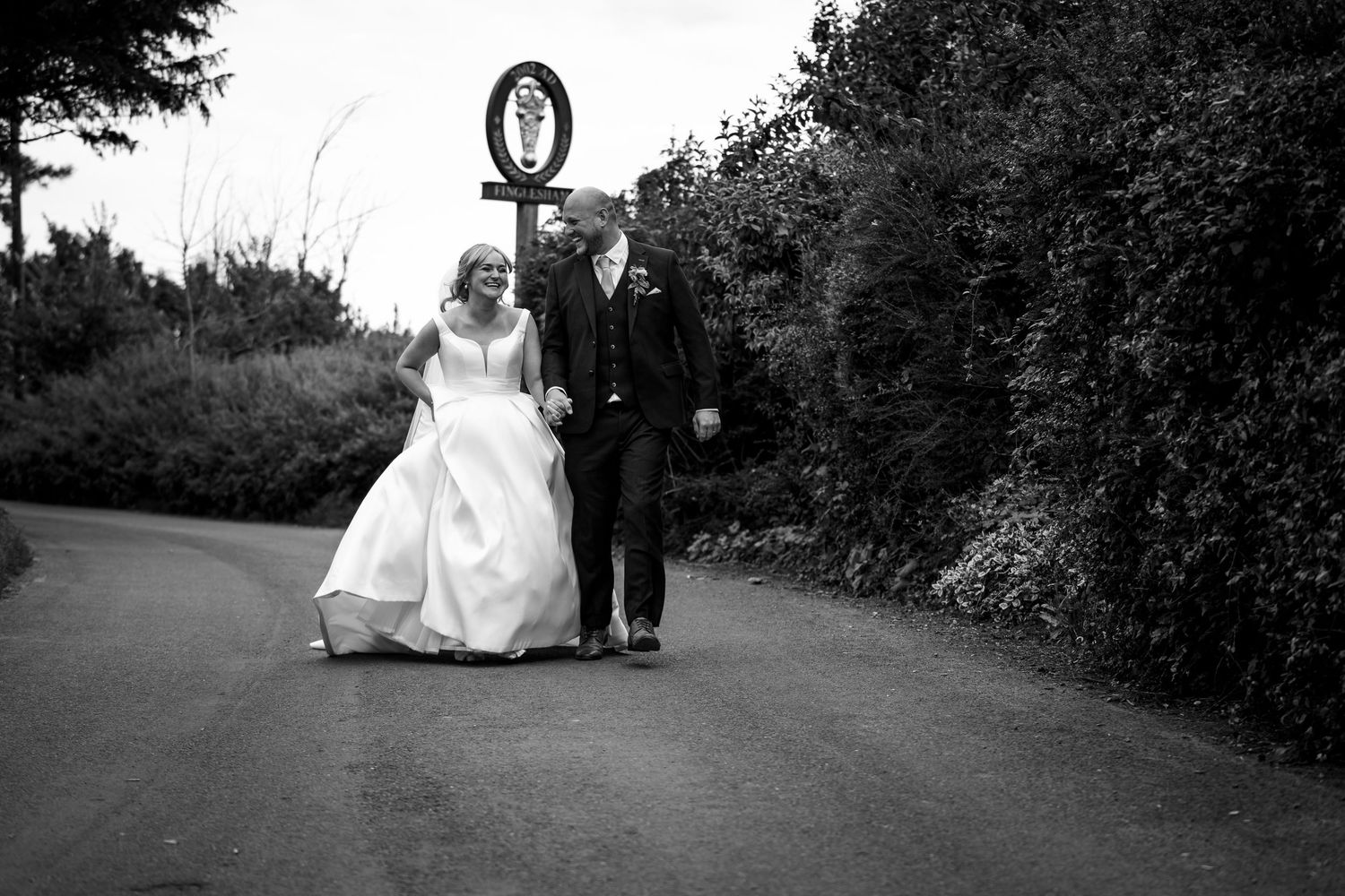 Black and white wedding photos showing a couple on a garden path.