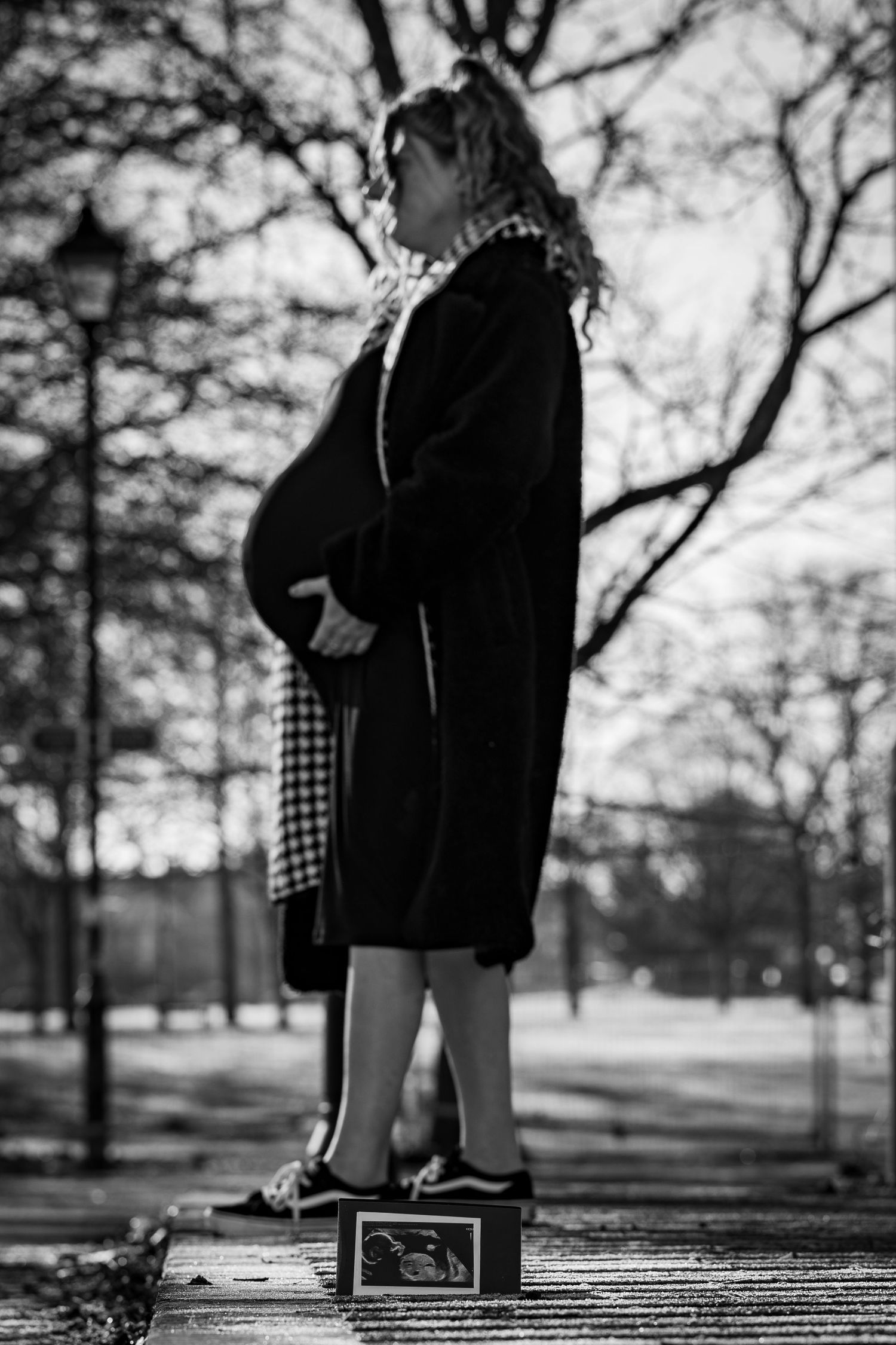 Artistic black and white photos on a wooden boardwalk in a park setting.