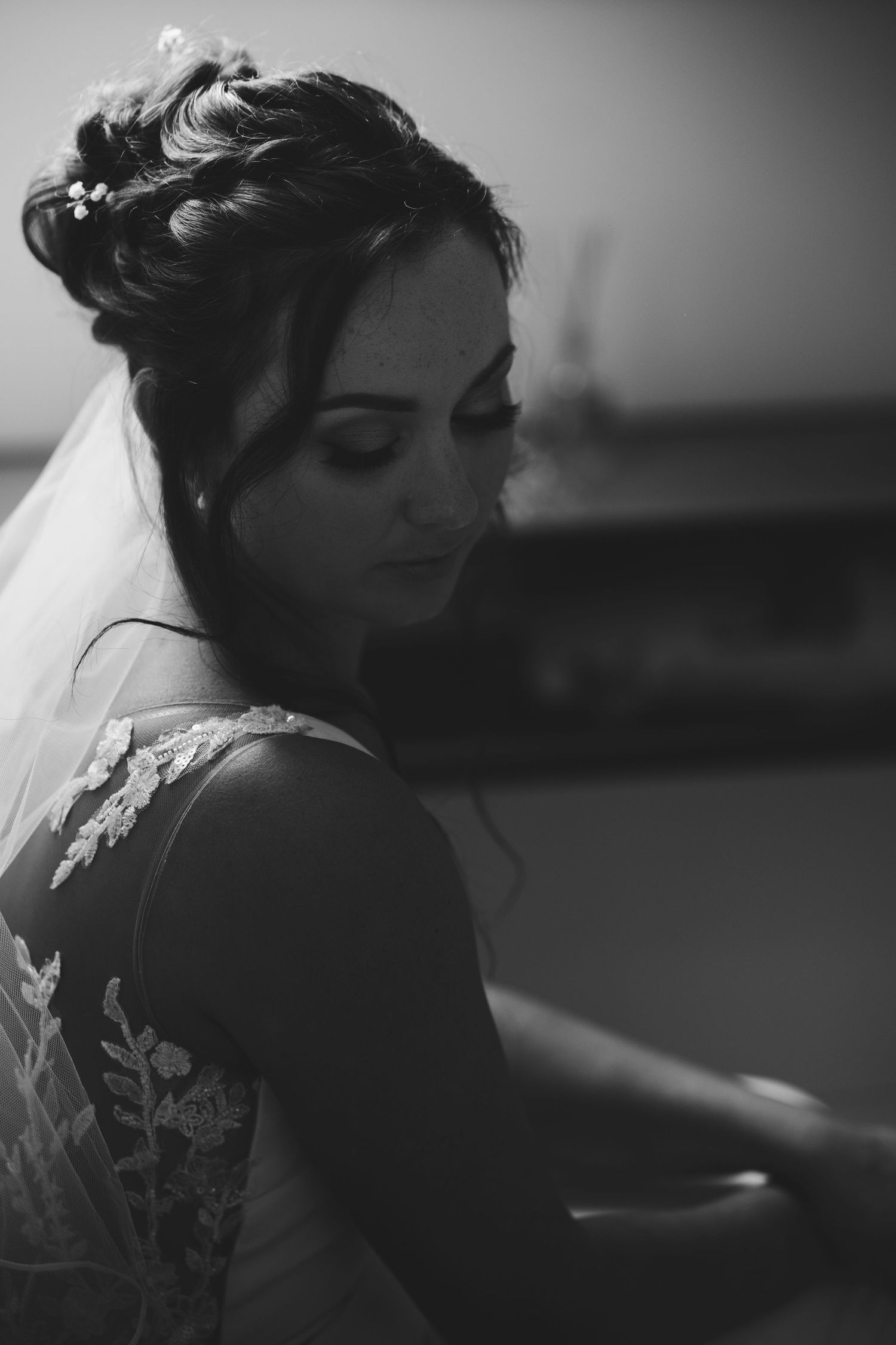 Artistic black and white close-up shots of a bride in an elegant lace wedding dress.