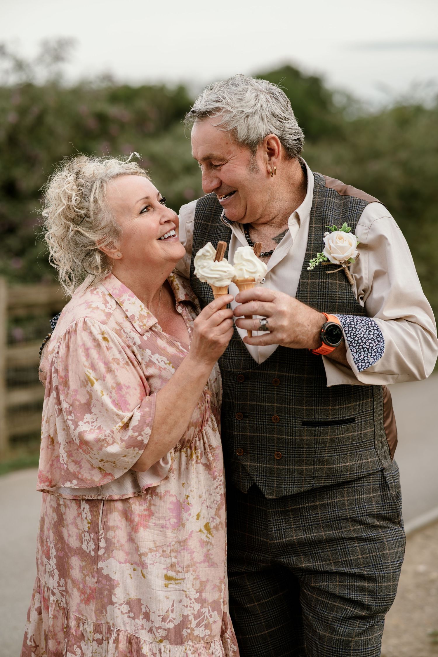 Playful couple sharing ice cream cones while dressed in vintage attire.