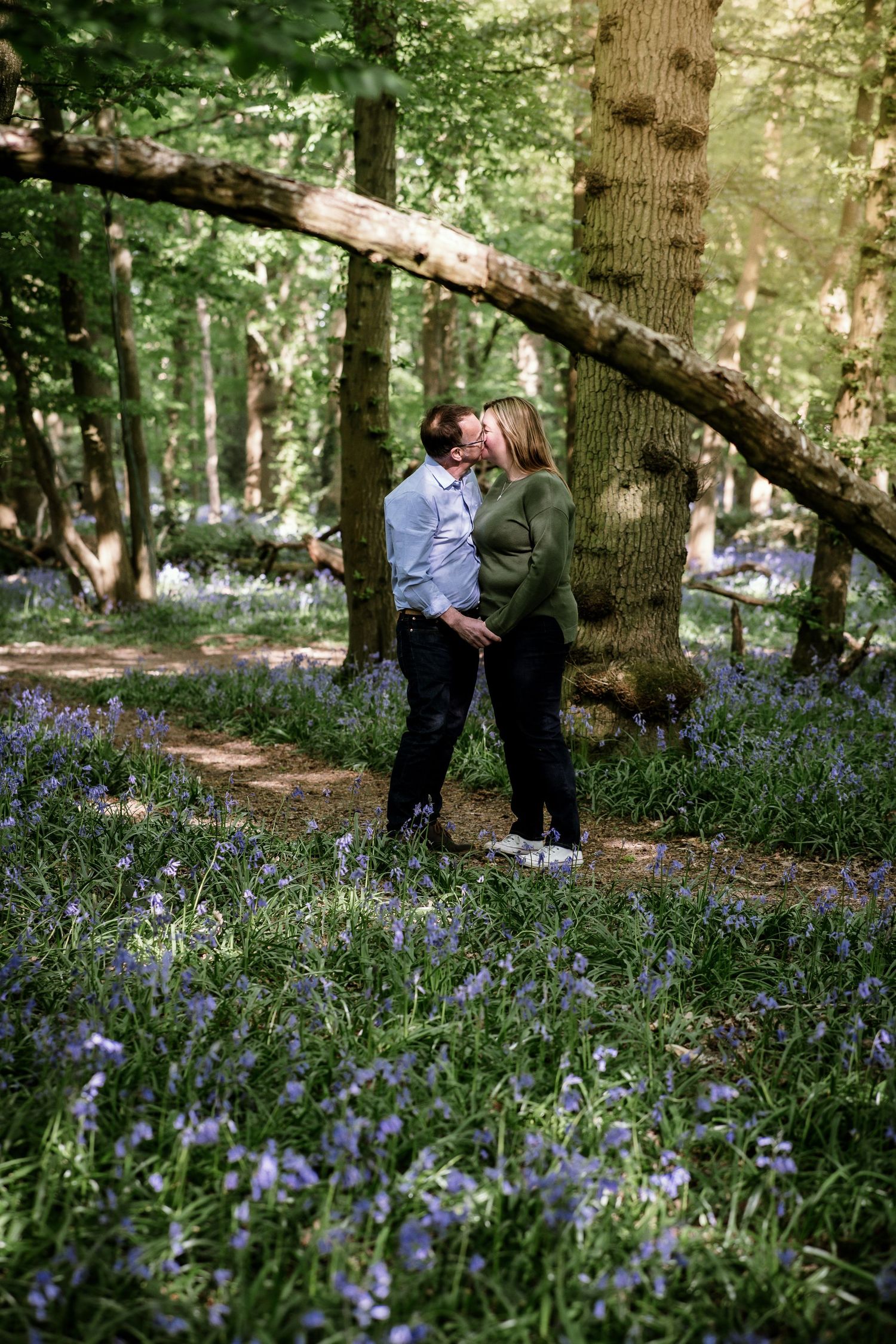 Couple walking through a beautiful bluebell forest during springtime.