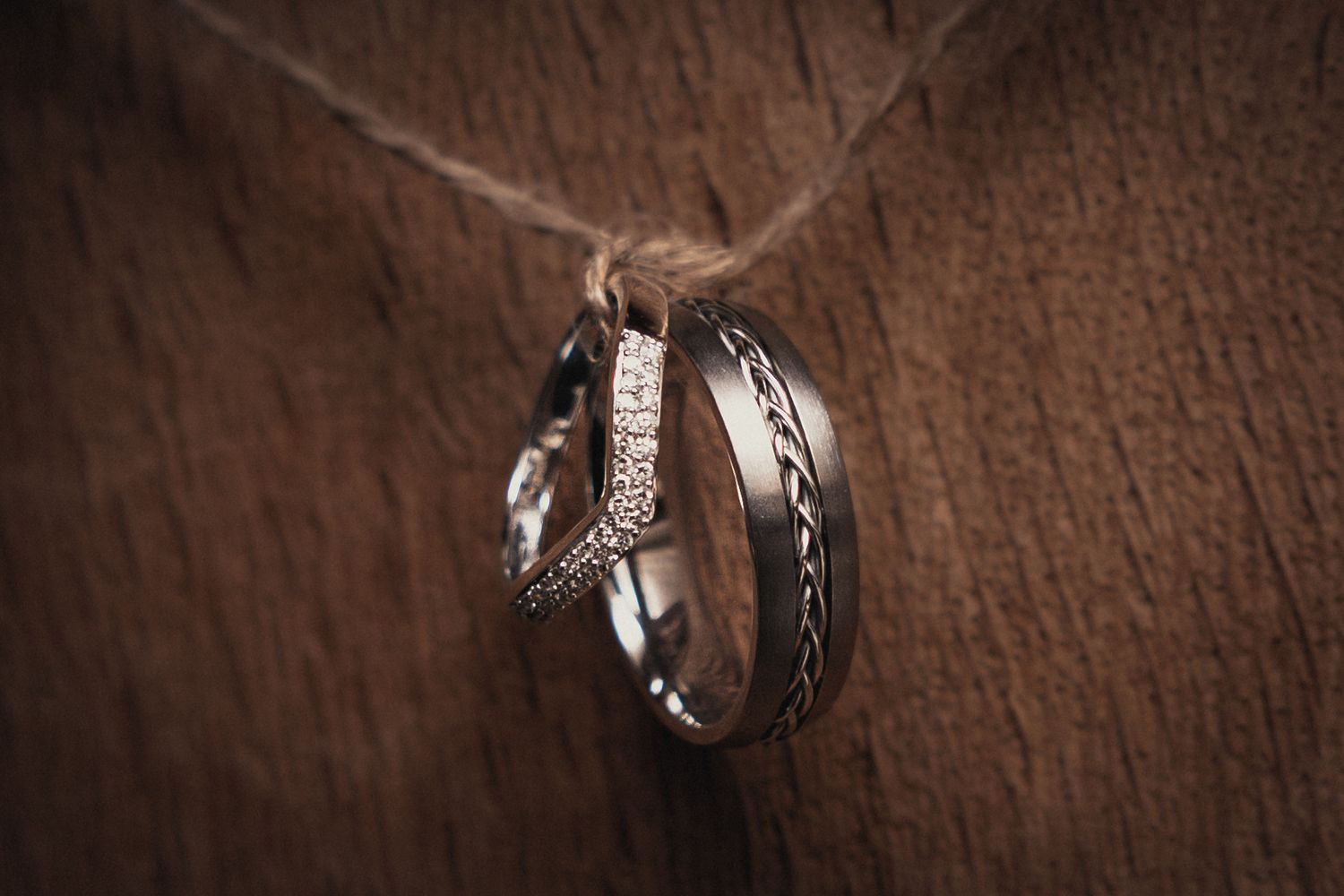 Wedding rings photographed with dramatic lighting on textured leather background.