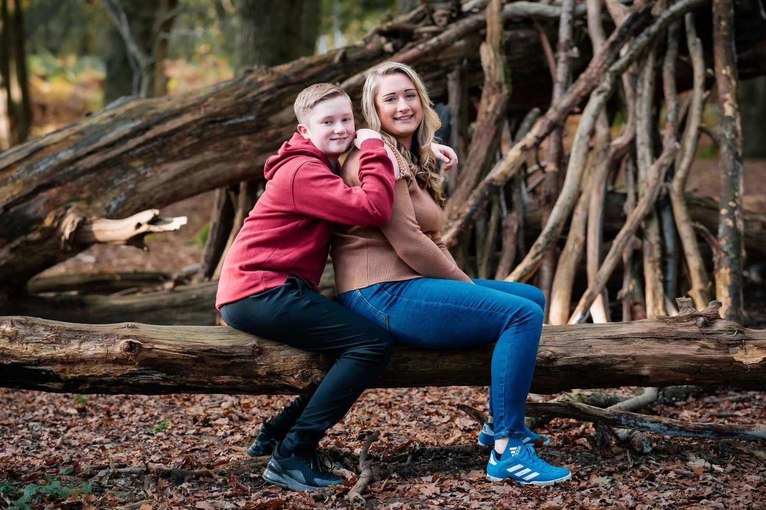 A couple explores a natural wooded area with exposed tree roots.