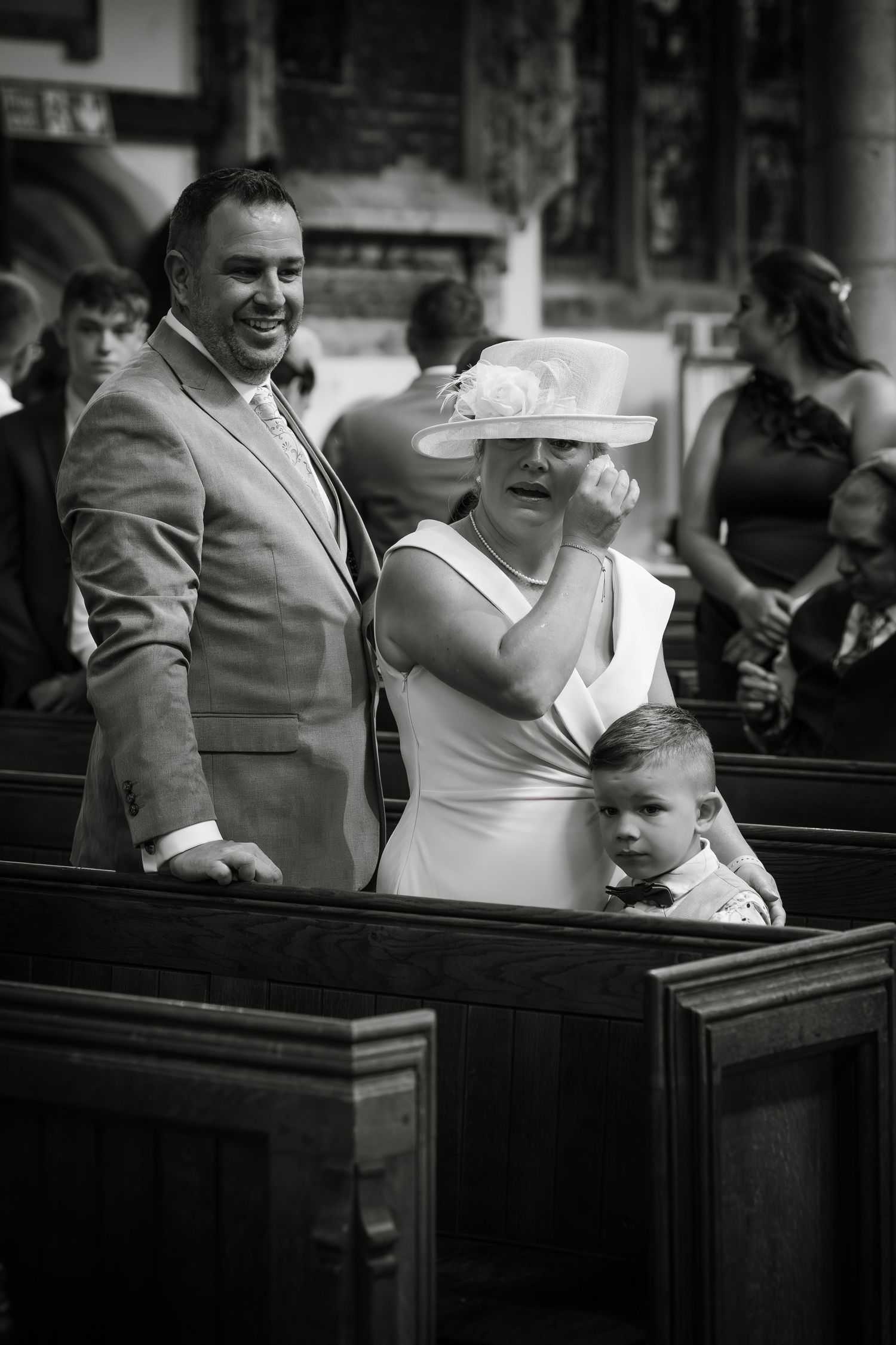 Wedding guests celebrate in church pews during a joyful ceremony.