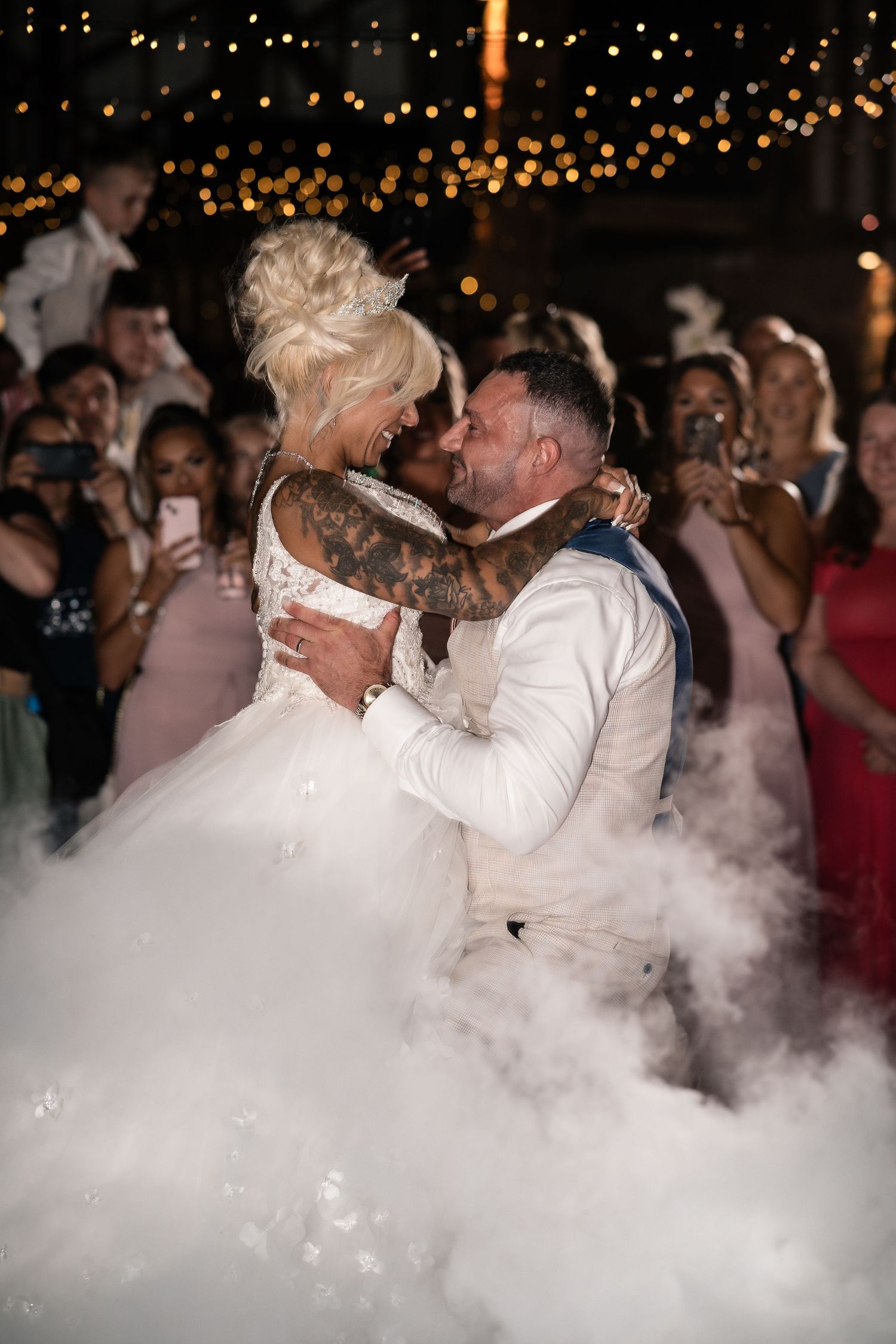 Romantic first dance with smoke effects and string lights creating dreamy atmosphere.