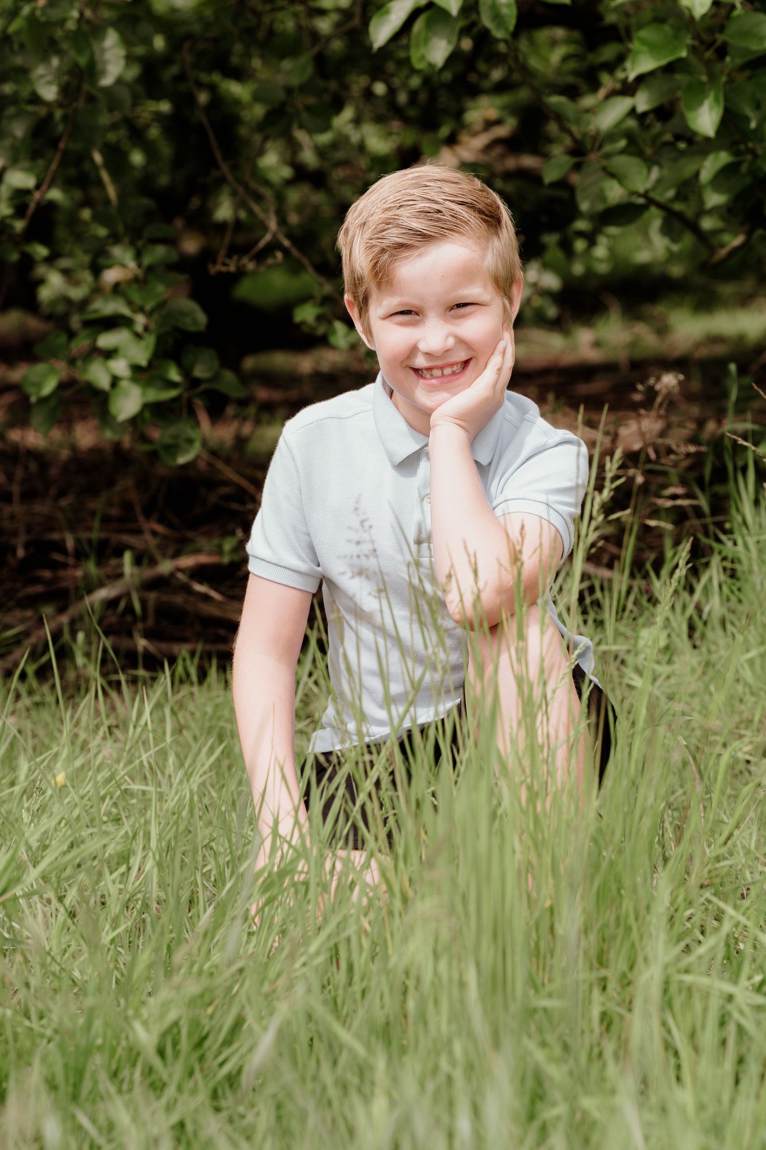 Playful poses in tall grass during a spring outdoor photo shoot.