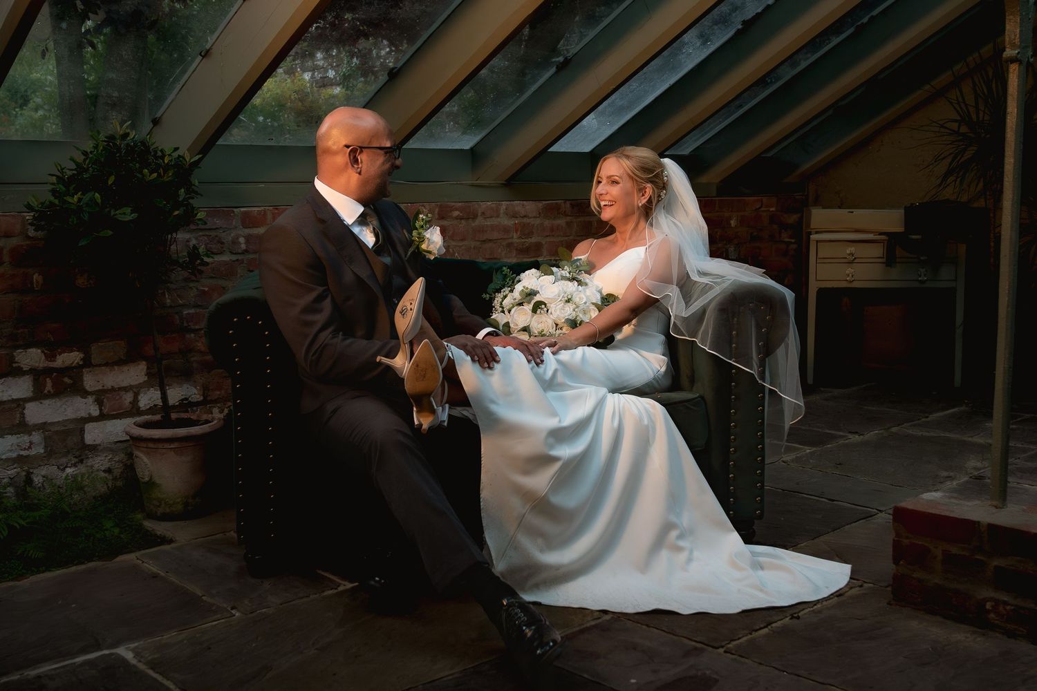 Wedding celebration under glass ceiling conservatory with natural lighting.