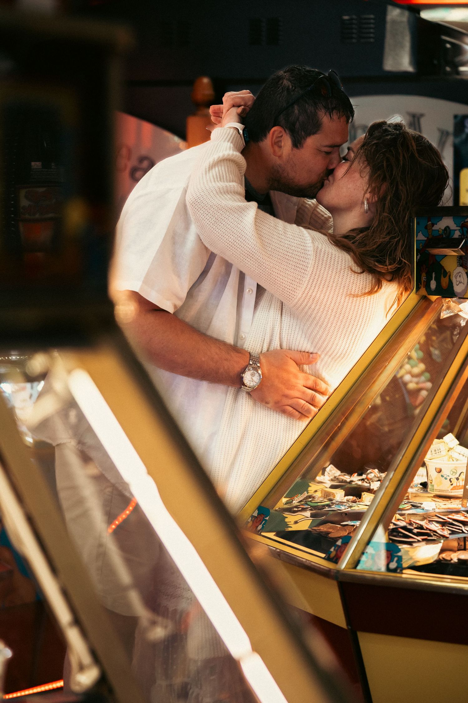 Romantic couple embracing in warm lighting against display cases.