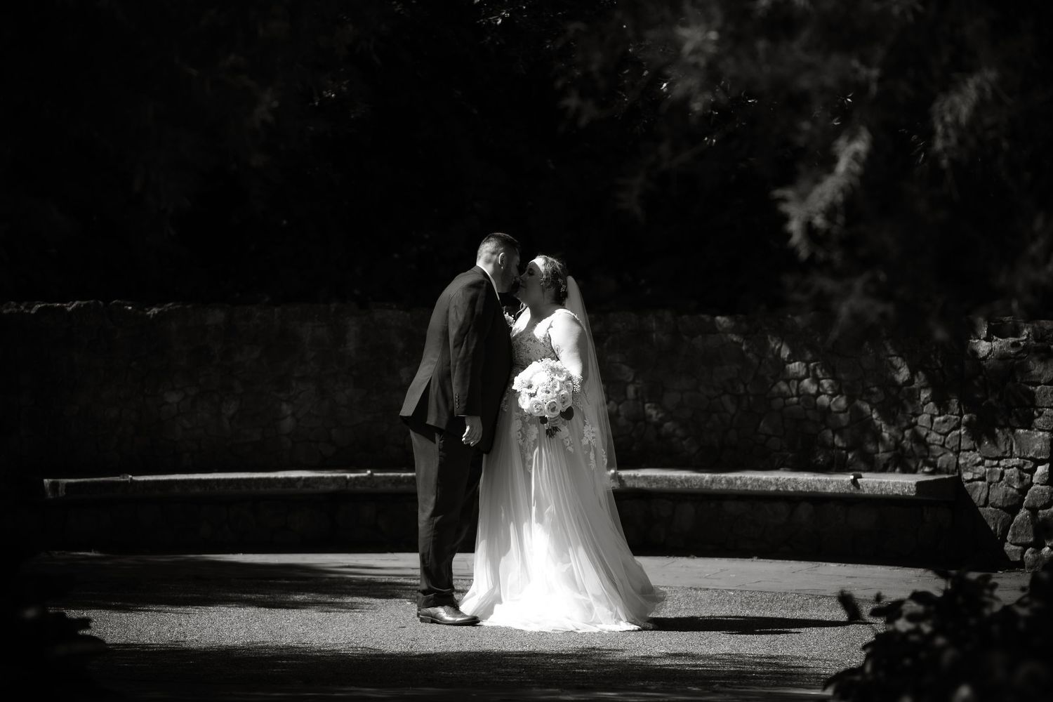 Wedding photography session in a shadowy garden setting.