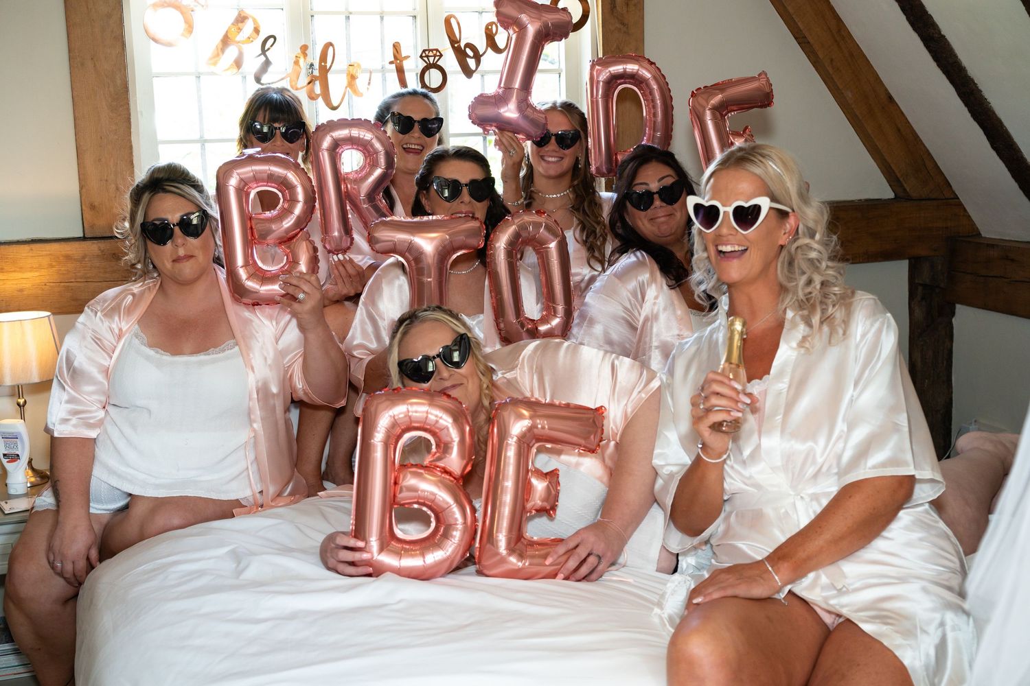 Wedding party members wearing sunglasses pose together for fun group photos.