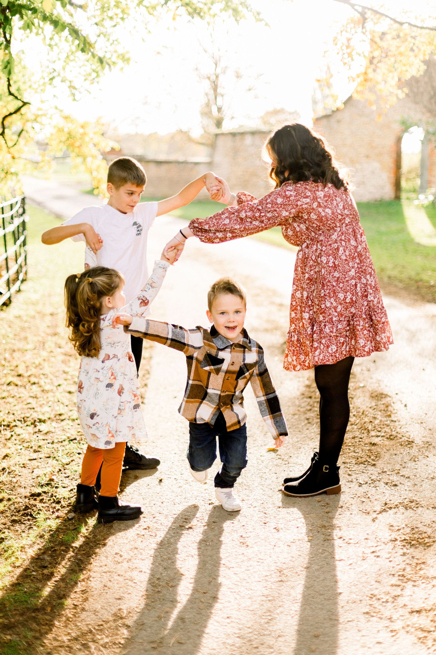 A sequence of four backlit photos showing playful movement and interaction between people in autumn sunlight.