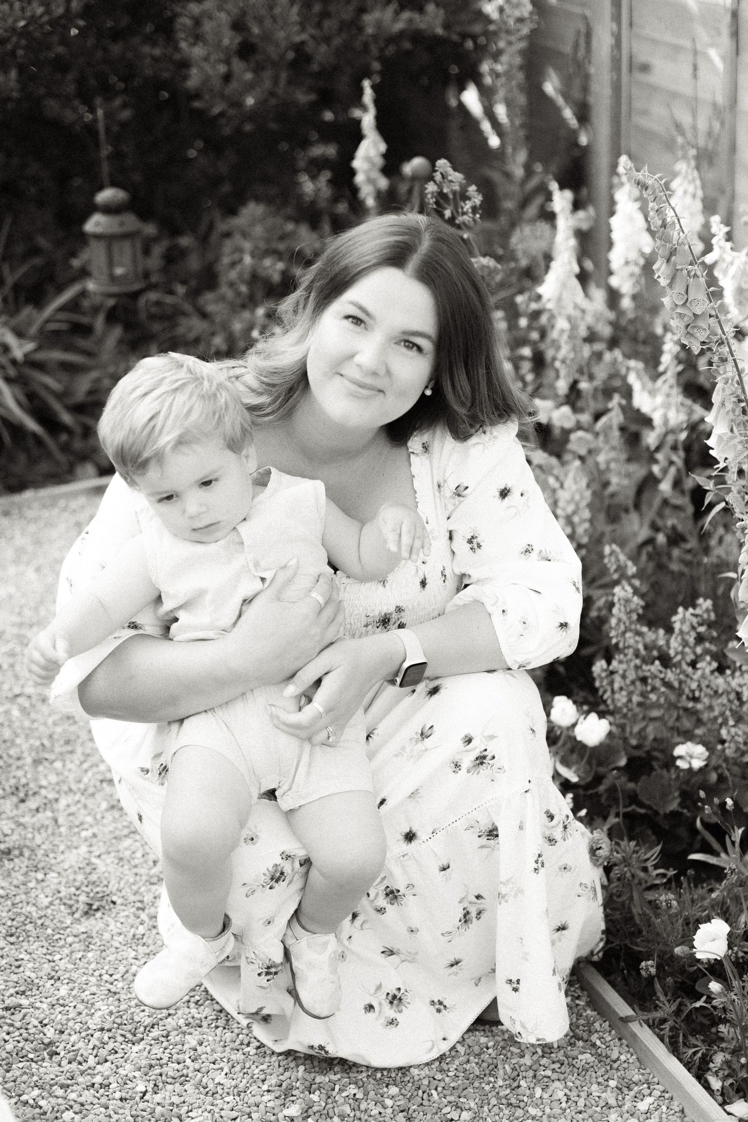 Sweet candid moments captured in black and white by a garden fence.