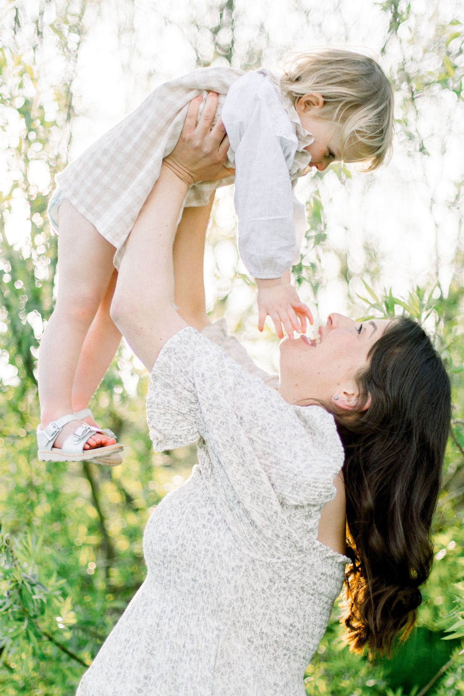 Playful outdoor moments between parent and child in matching white outfits.