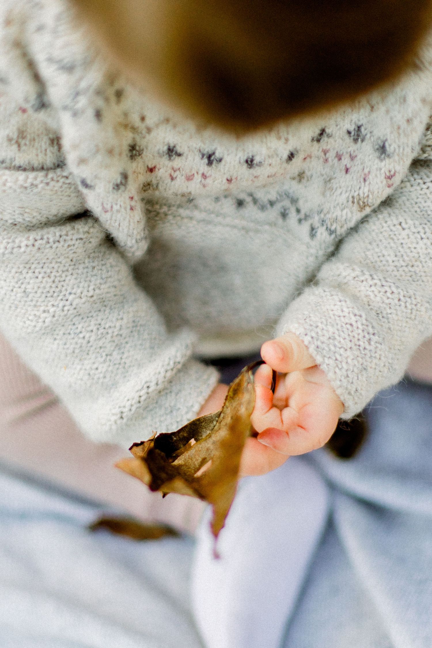 Delicate lace details and tiny hands captured in soft focus.