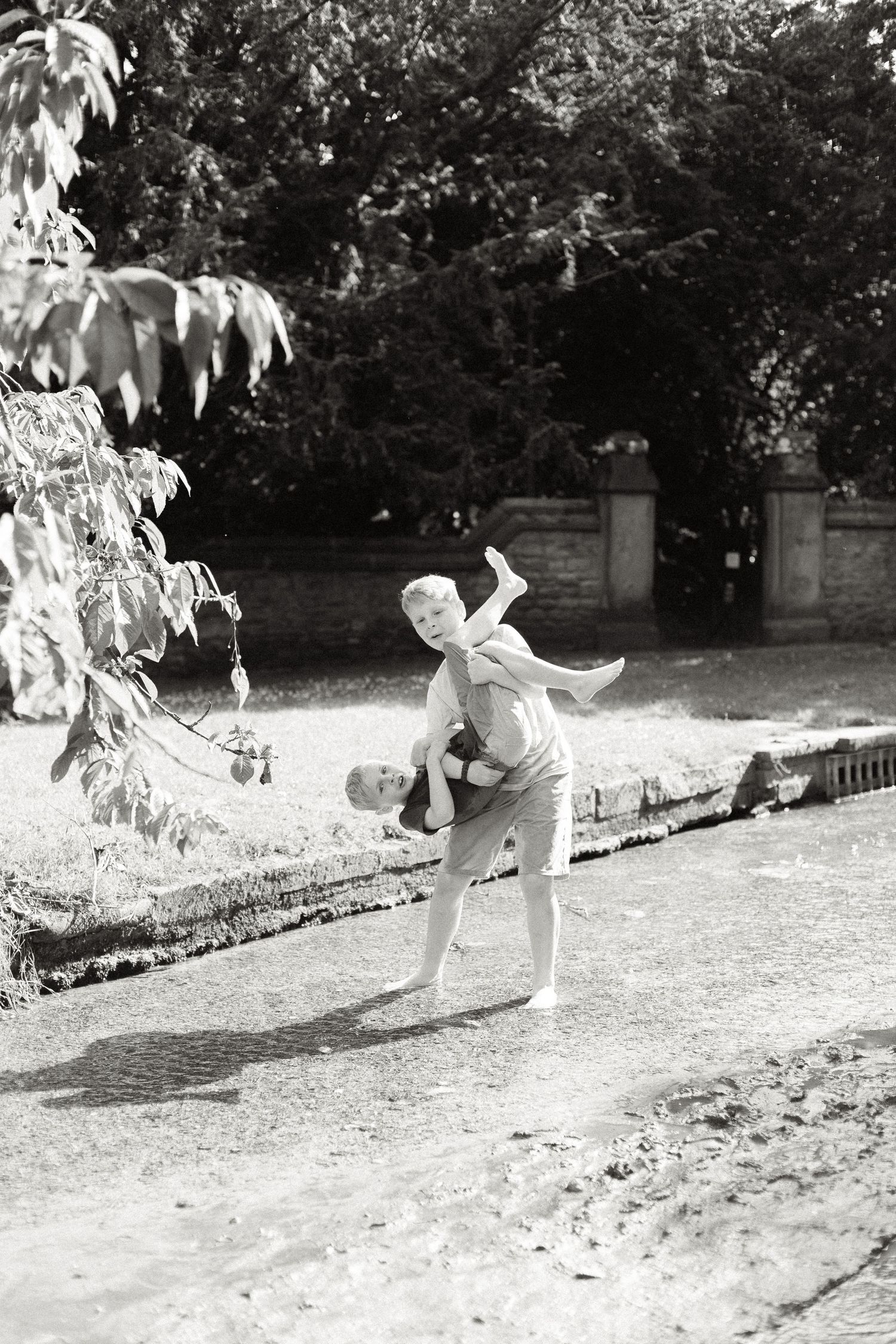 Vintage black and white photo of someone in playful dance pose outdoors.
