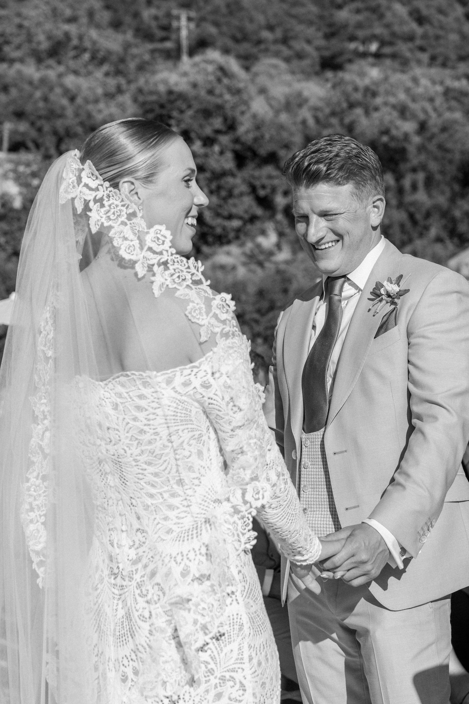 Romantic wedding moment captured in black and white with lace veil details.