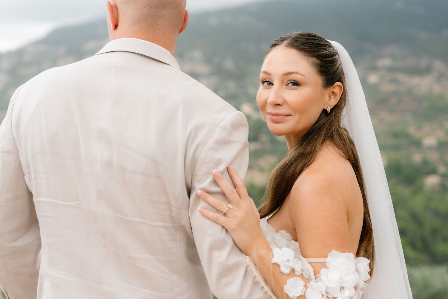 Romantic wedding portraits against scenic coastal mountain backdrop.