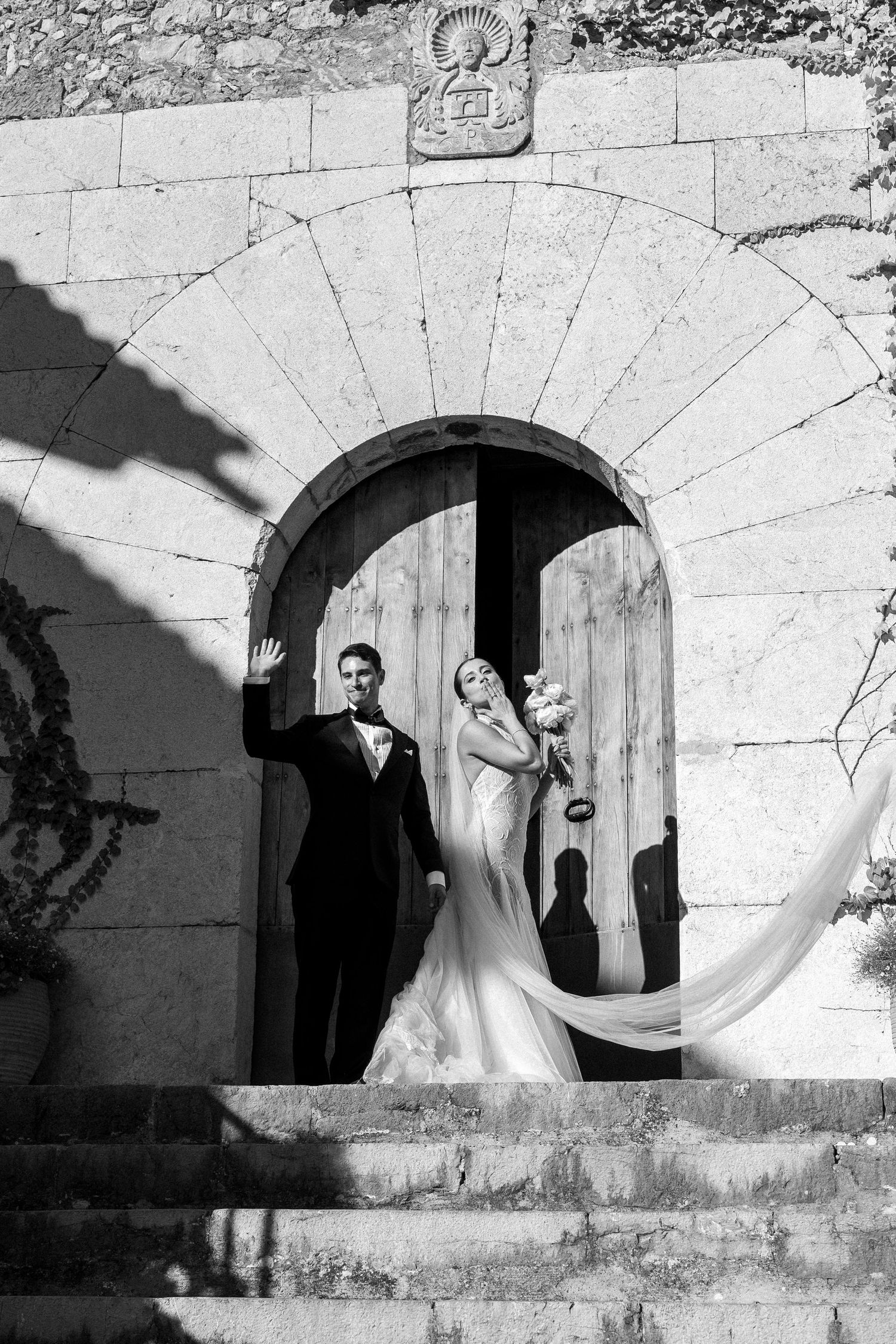 Artistic black and white wedding photos taken through stone archways.