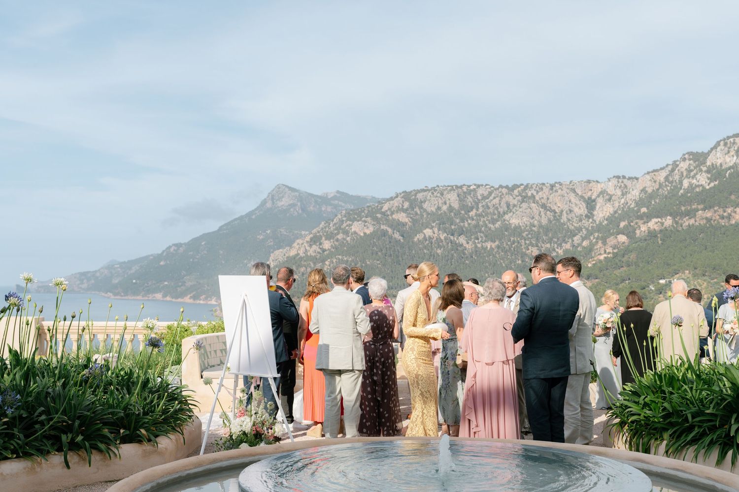 Outdoor wedding ceremony setup with mountain views and rows of white chairs.
