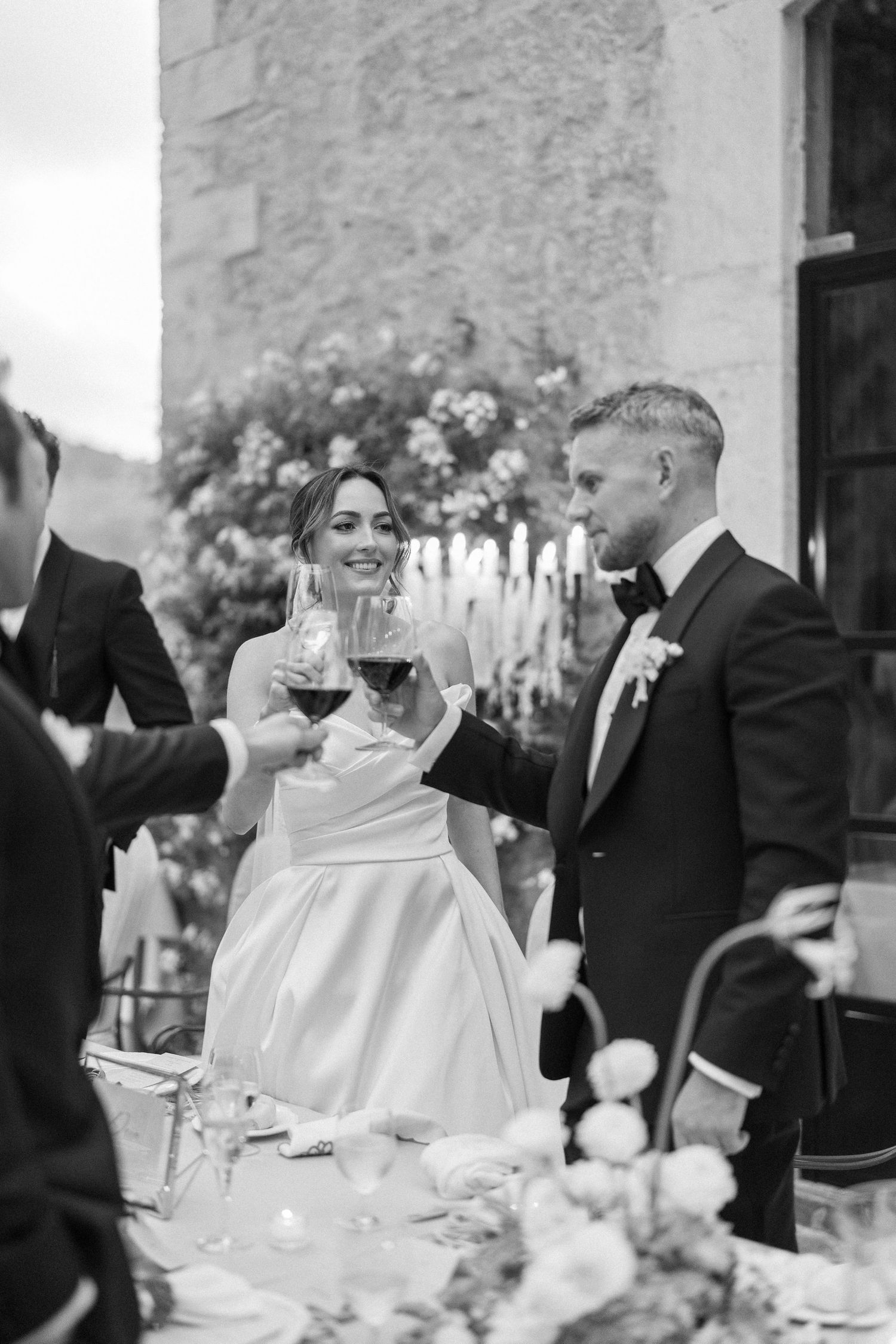 Wedding reception scene with guests toasting at an elegant stone venue.