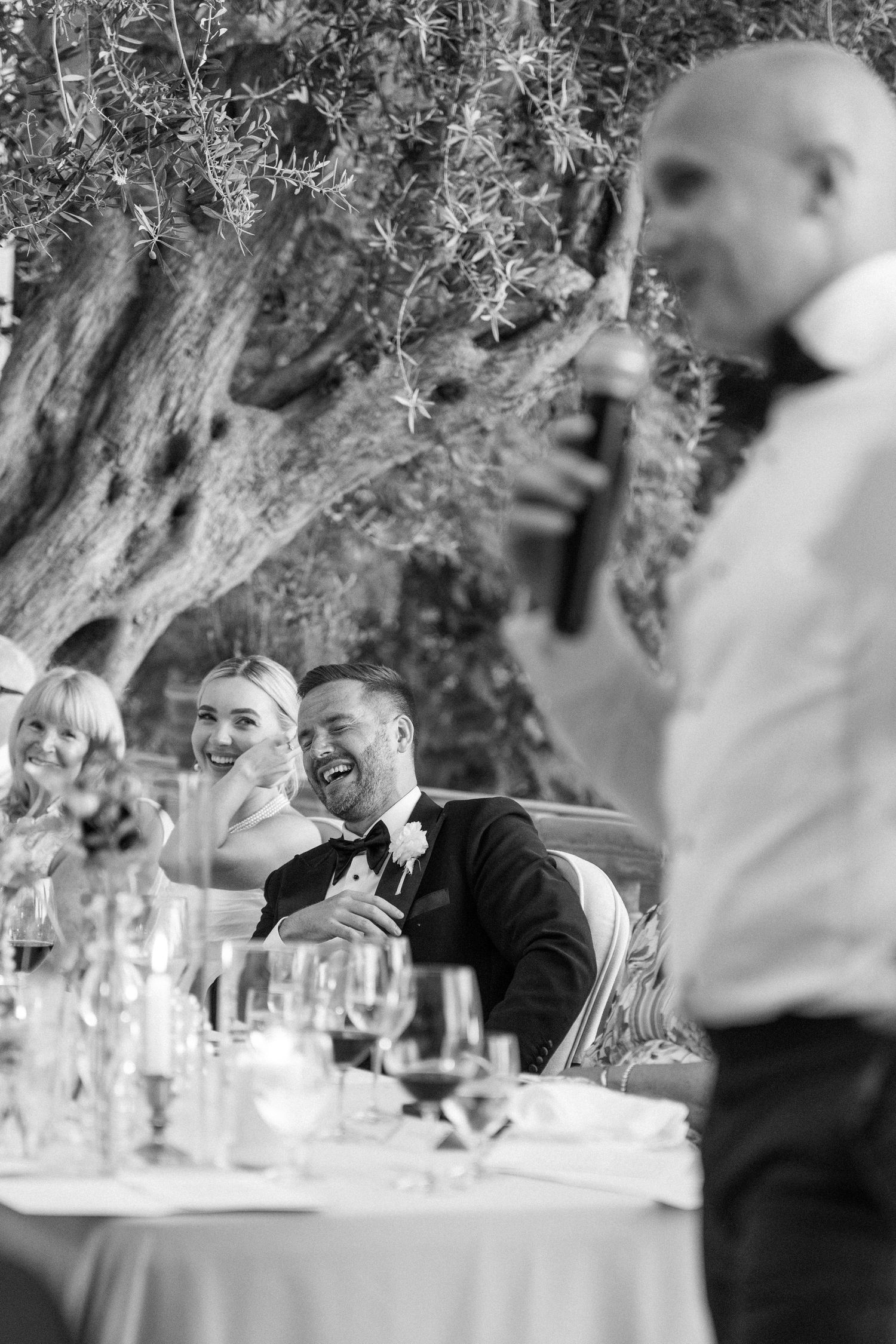 Black and white candid shots of wedding guests enjoying the reception.