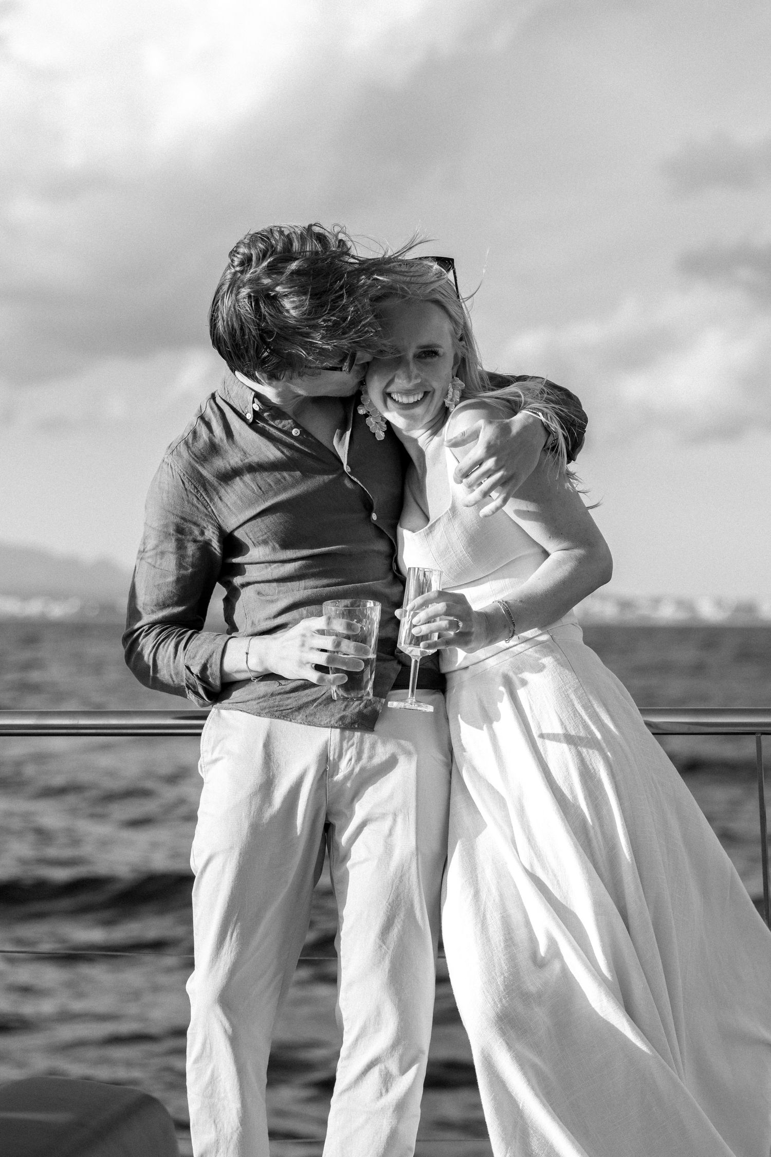 Two people embracing and laughing during a celebration at sea.