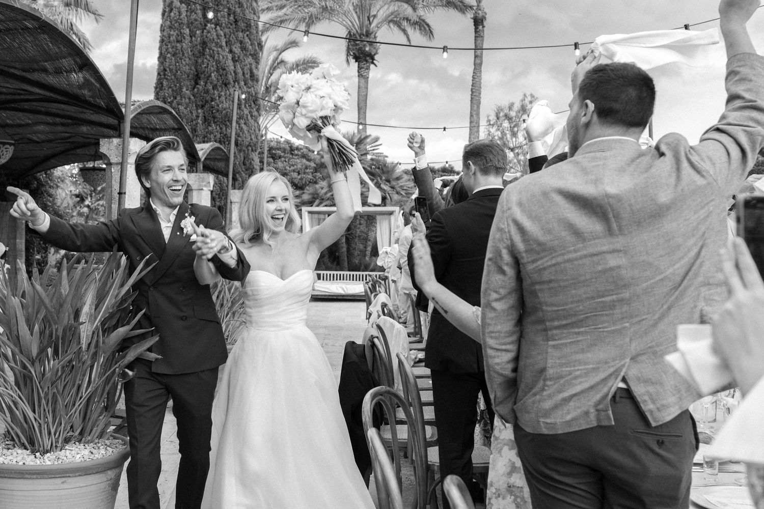 Wedding celebration with guests dancing and enjoying festivities outdoors.