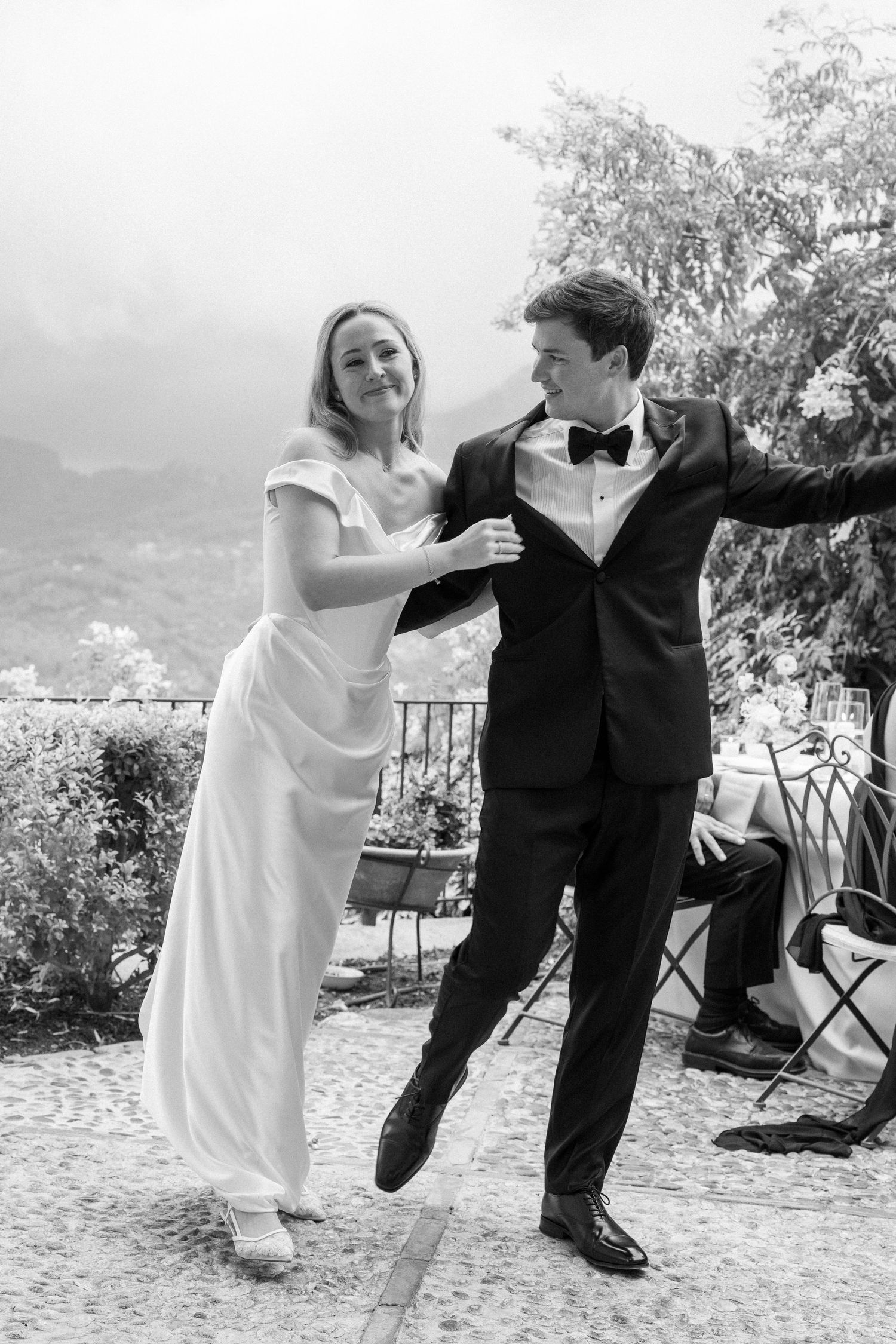 Wedding couple dancing and kicking up their feet in a series of joyful black and white photos.