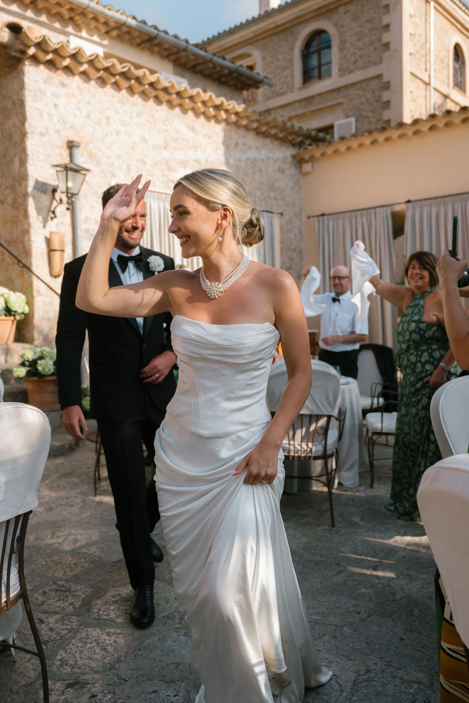 Joyful dance moments during a wedding celebration in a Mediterranean courtyard.