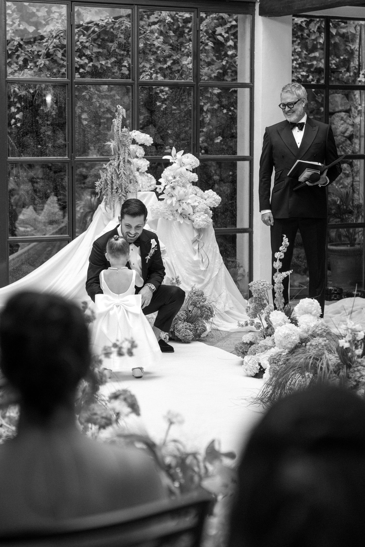 A series of black and white candid moments from a wedding reception showing guests seated at decorated tables.
