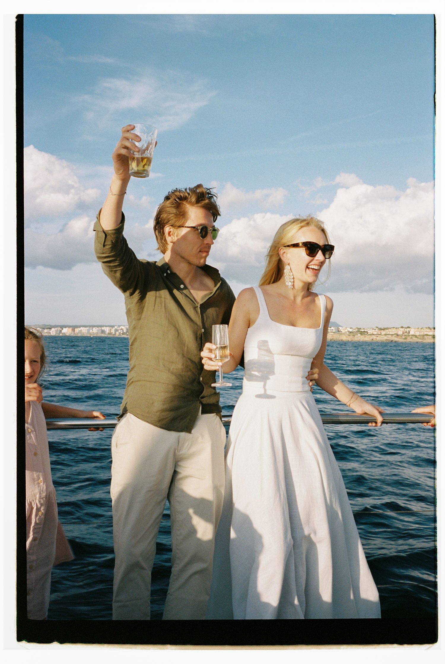 Guests celebrating on a boat deck with ocean views in the background.