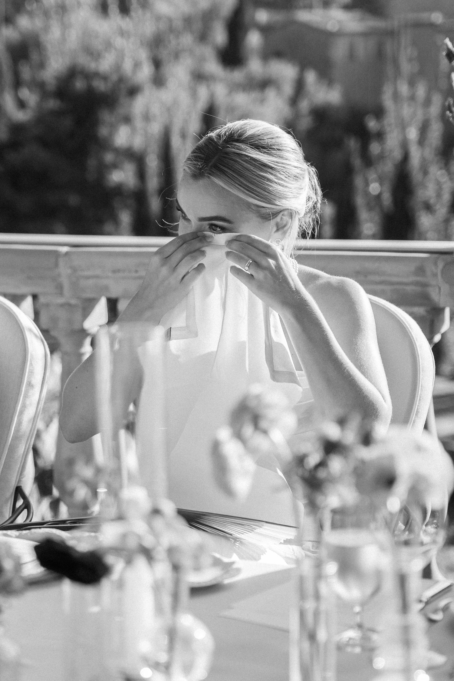 Elegant table settings with wine glasses and floral centerpieces at an outdoor wedding reception.