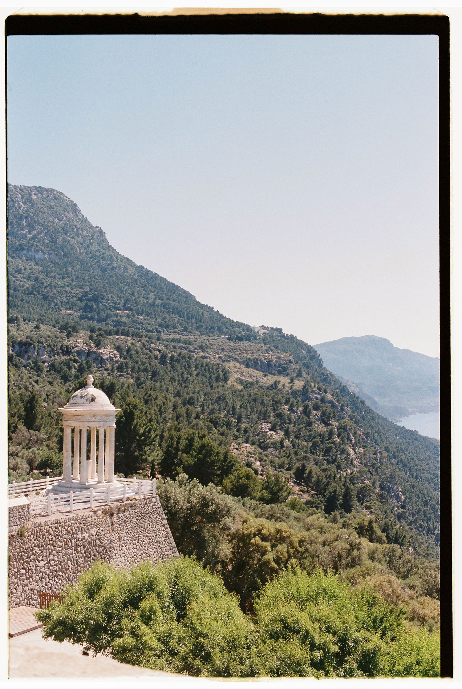 Mediterranean landscape with domed architectural structure nestled in mountainous terrain.