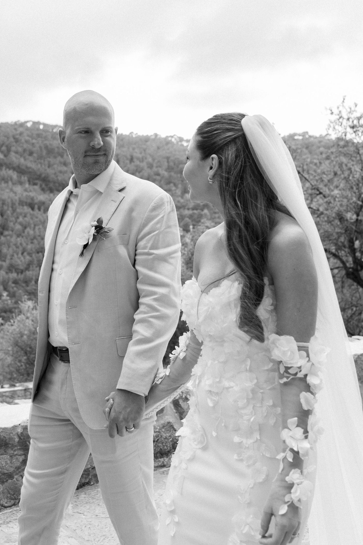 Wedding couple shares intimate moment against scenic mountain backdrop.