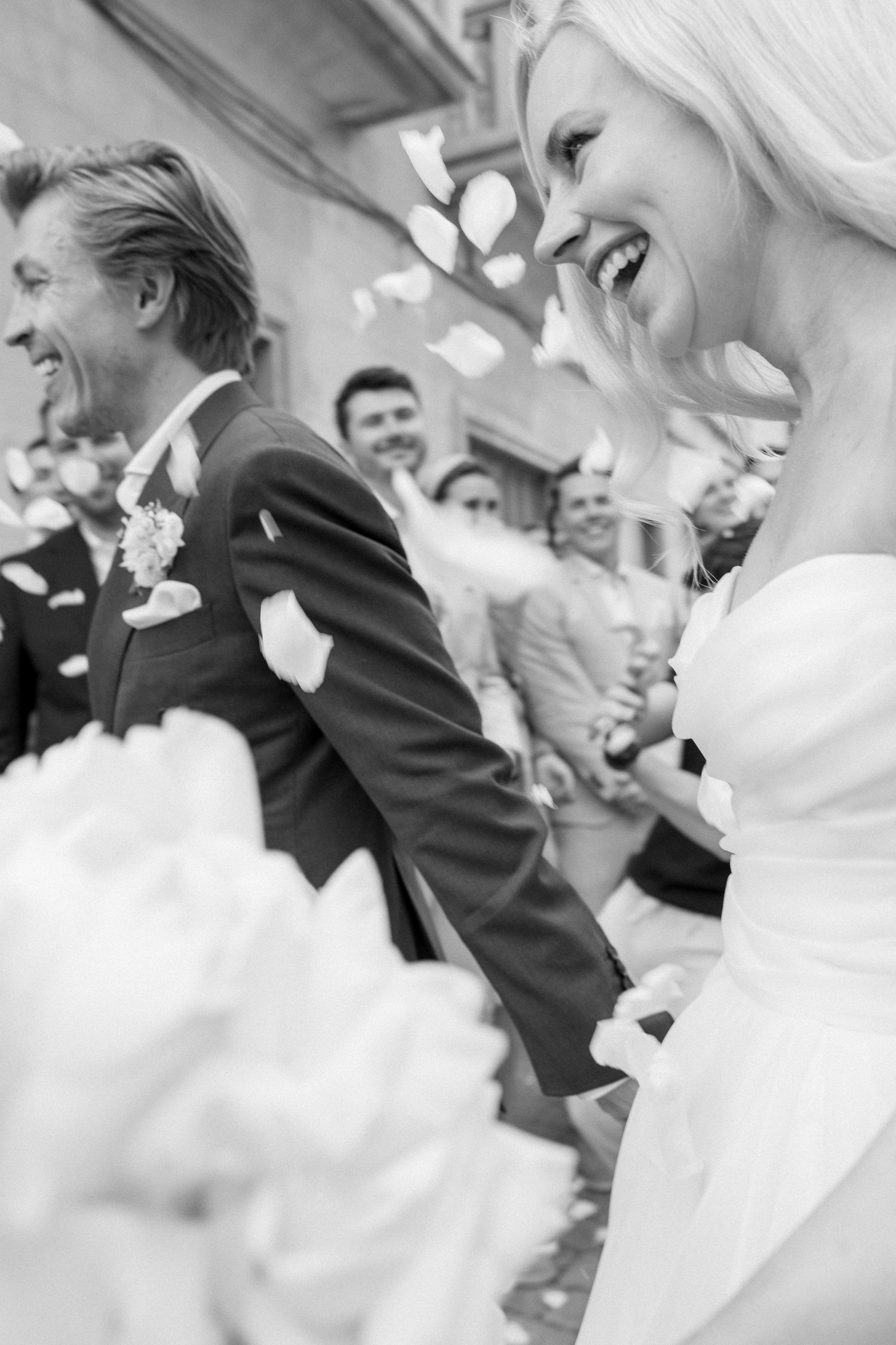 Joyful candid moments captured during wedding celebration in black and white.